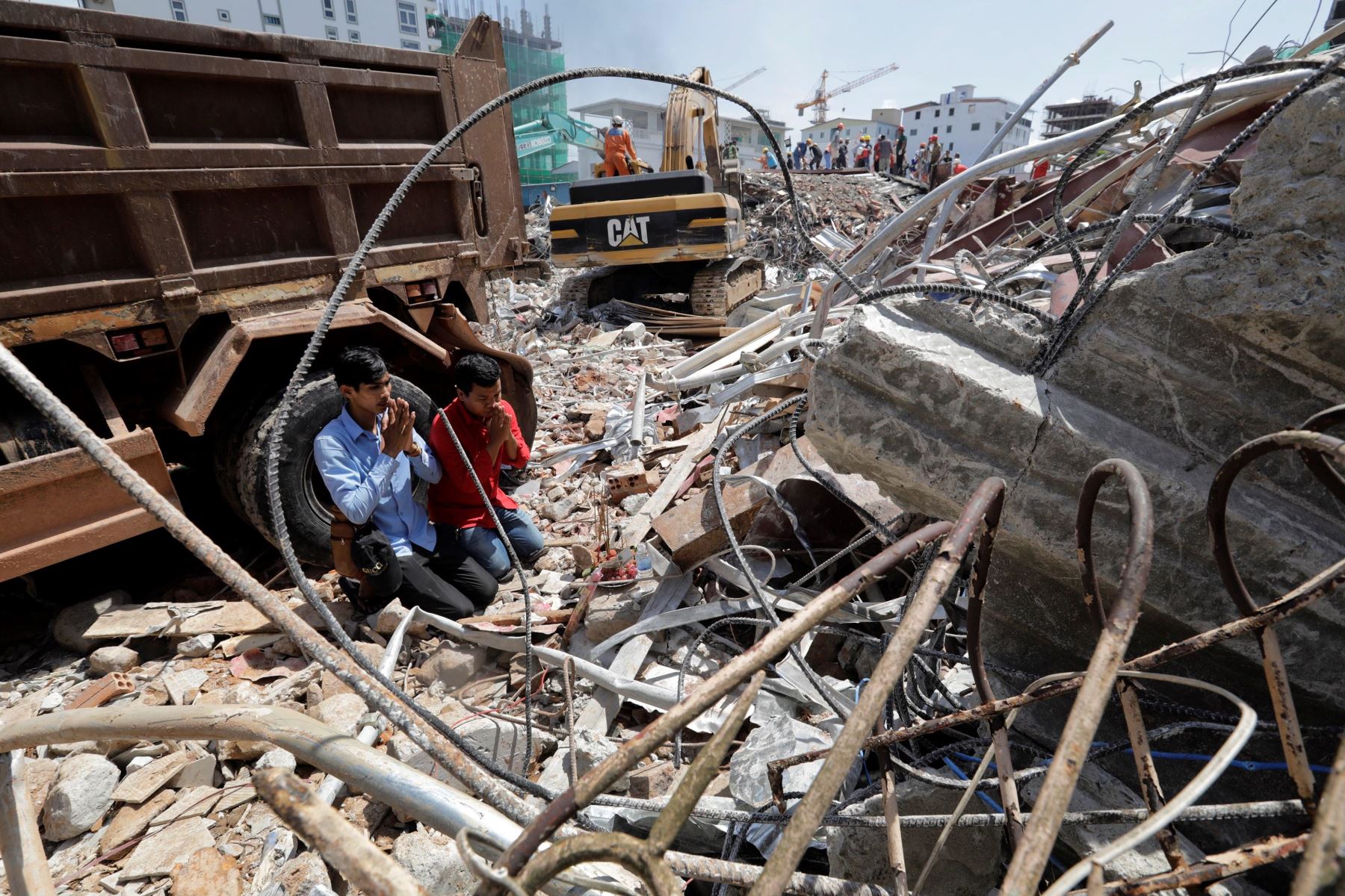Camboyanos rezan por sus familiares desaparecidos en el lugar en el que se derrumbó un edificio en construcción en Sihanoukville.
En el derrumbe fallecieron 17 personas.
Foto : EFE