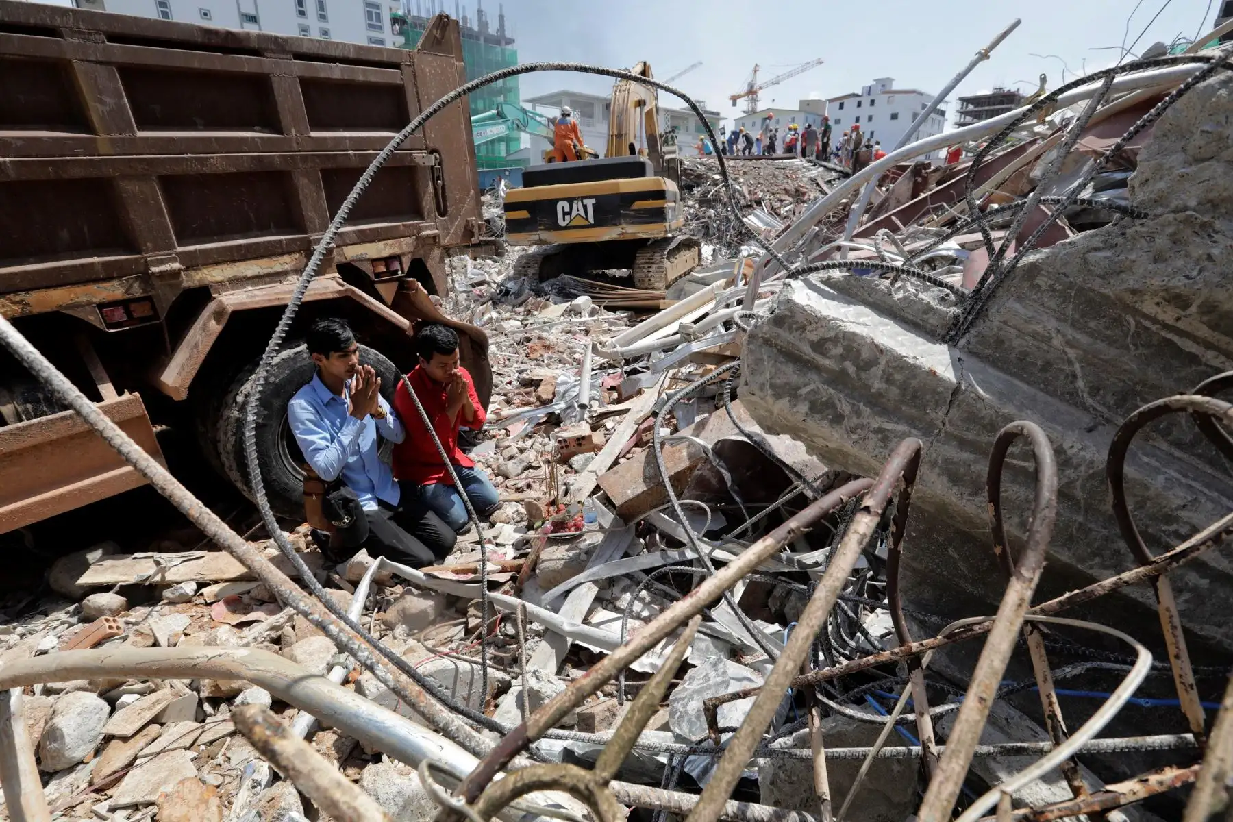 Camboyanos rezan por sus familiares desaparecidos en el lugar en el que se derrumbó un edificio en construcción en Sihanoukville.
En el derrumbe fallecieron 17 personas.
Foto : EFE