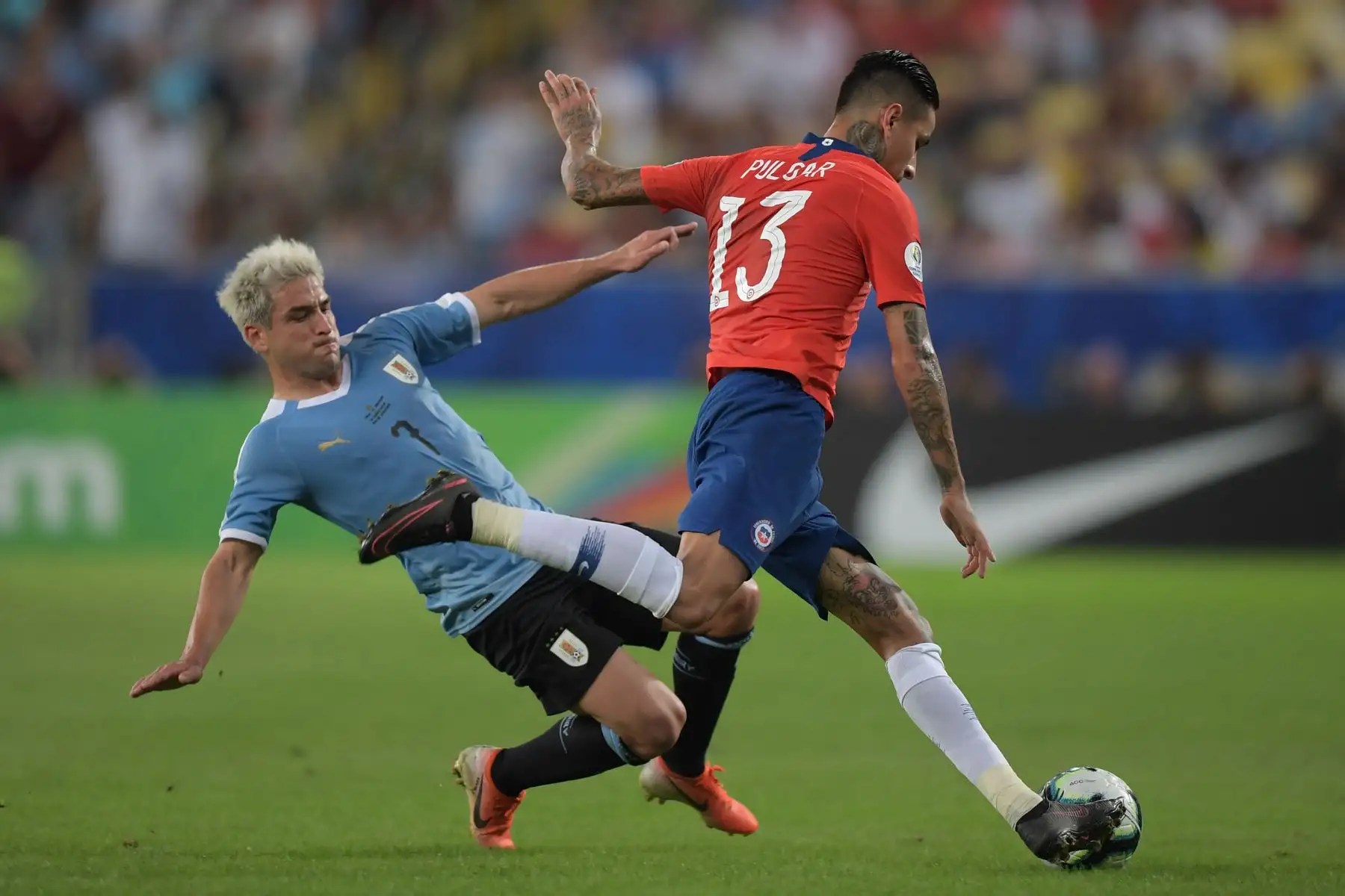 El chileno Erick Pulgar (R) está marcado por el uruguayo Nicolás Lodeiro durante el partido de torneo de fútbol de la Copa América en el estadio Maracana en Río de Janeiro, Brasil.Foto:AFP