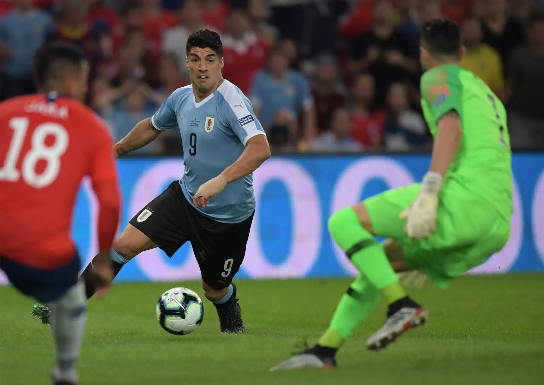 Luis Suárez (R), de Uruguay, trata de anotar a Gonzalo Jara (L) de Chile y al arquero Gabriel Arias durante el partido de torneo de fútbol de la Copa América en el Estadio Maracaná de Río de Janeiro, Brasil.Foto:AFP