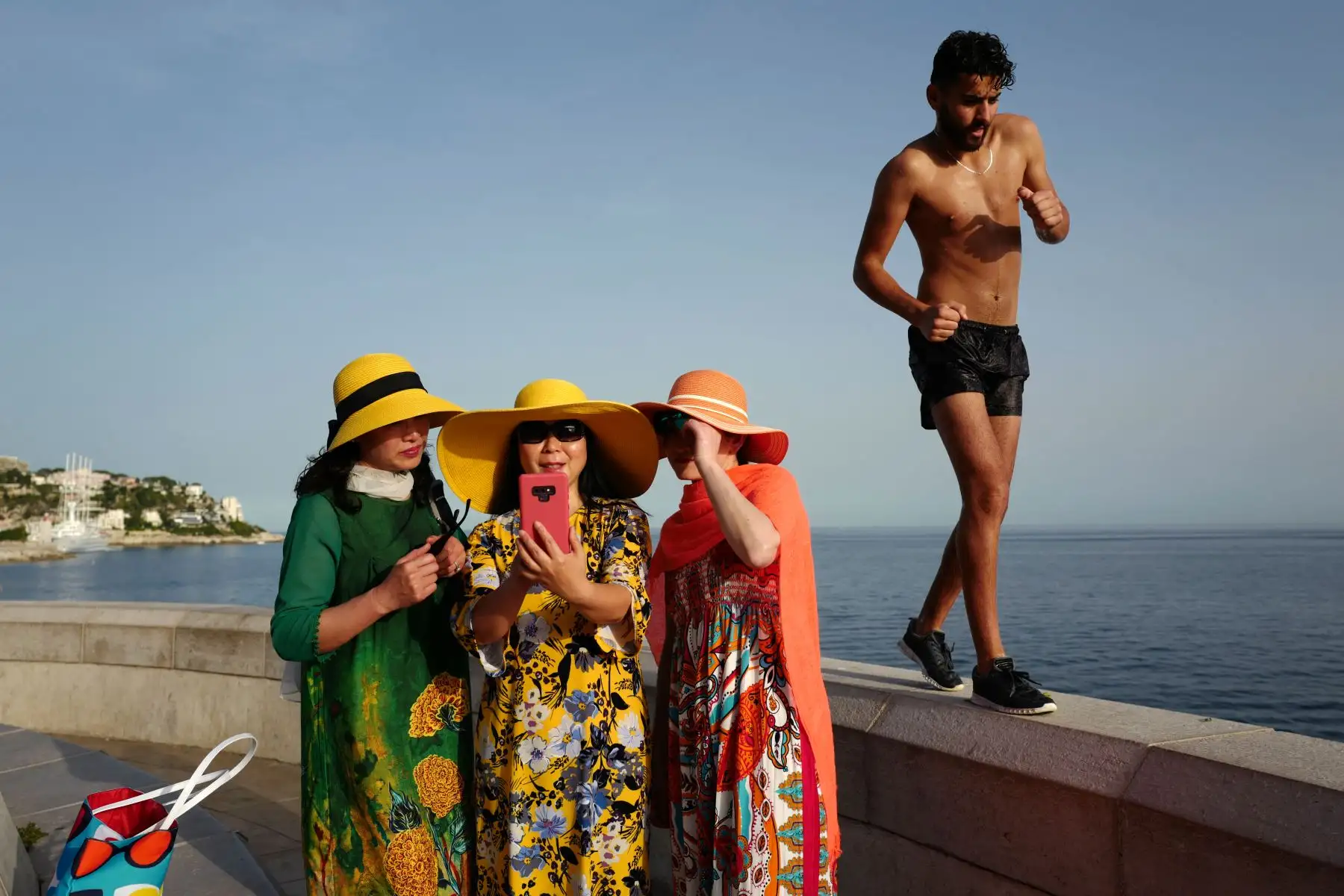 Un hombre pasa mientras los turistas toman selfies en la ciudad de la Riviera francesa de Niza, mientras las temperaturas se elevan a 33 grados centígrados. Foto: AFP