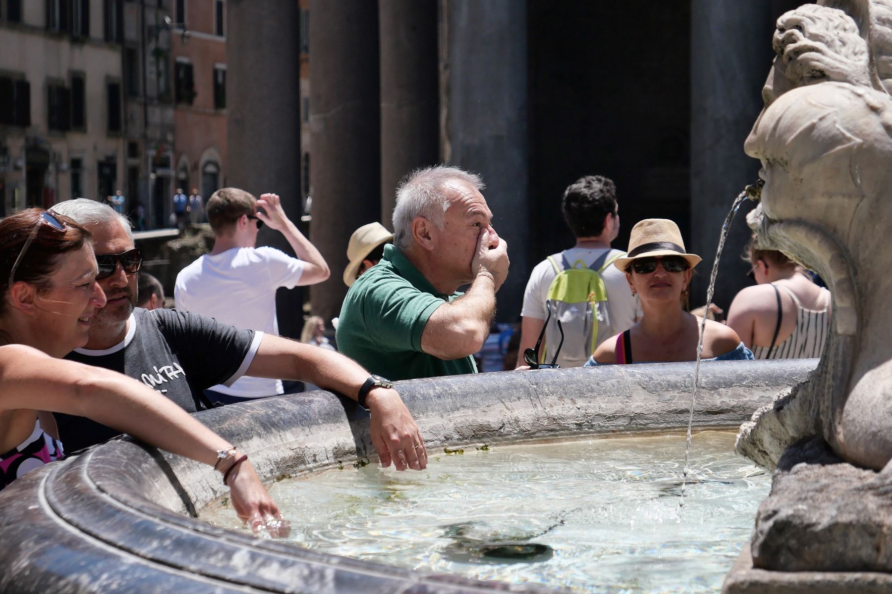 Turistas se refrescan en la Fontana della Barcaccia en Piazzia di Spagna en el centro de Roma durante una inusual ola de calor. Foto: AFP