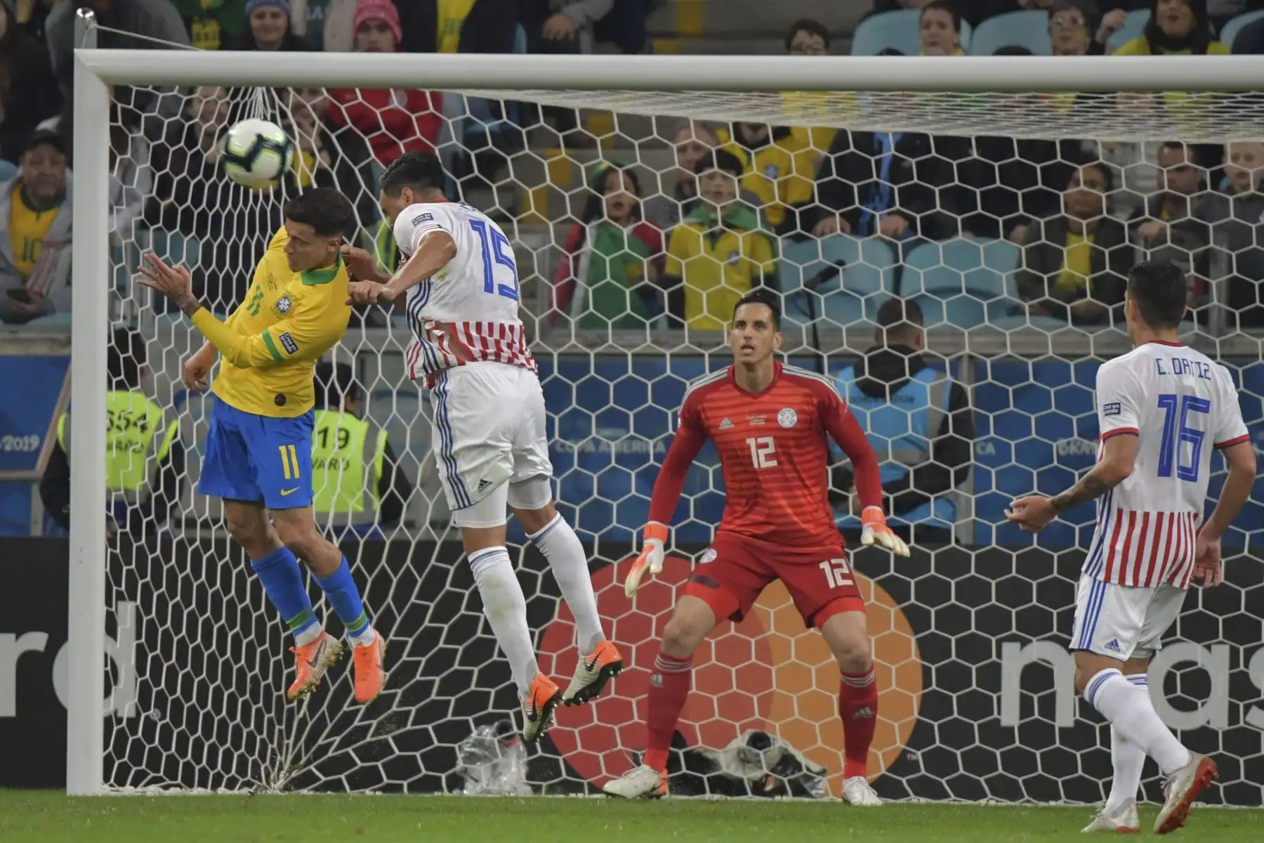 El brasileño Philippe Coutinho (L) y el paraguayo Gustavo Gómez saltan a la pelota cuando el arquero paraguayo Roberto Fernández se pierde durante su partido de cuartos de final del torneo de fútbol de América en el Gremio Arena de Porto Alegre, Brasil.Foto:AFP