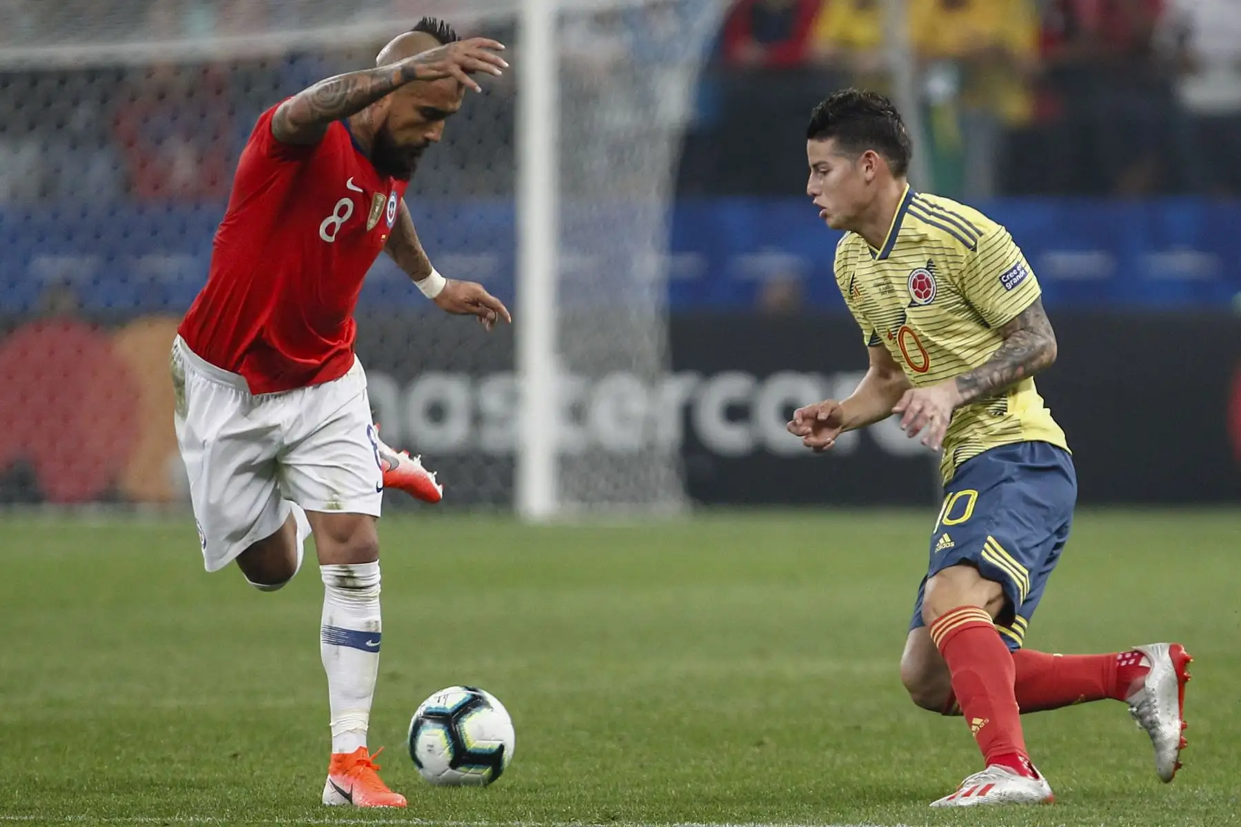 Arturo Vidal (L) de Chile y James Rodríguez de Colombia compitieron por el balón durante su partido de los cuartos de final del torneo de fútbol de la Copa América en el Corinthians Arena en Sao Paulo, Brasil.Foto:AFP