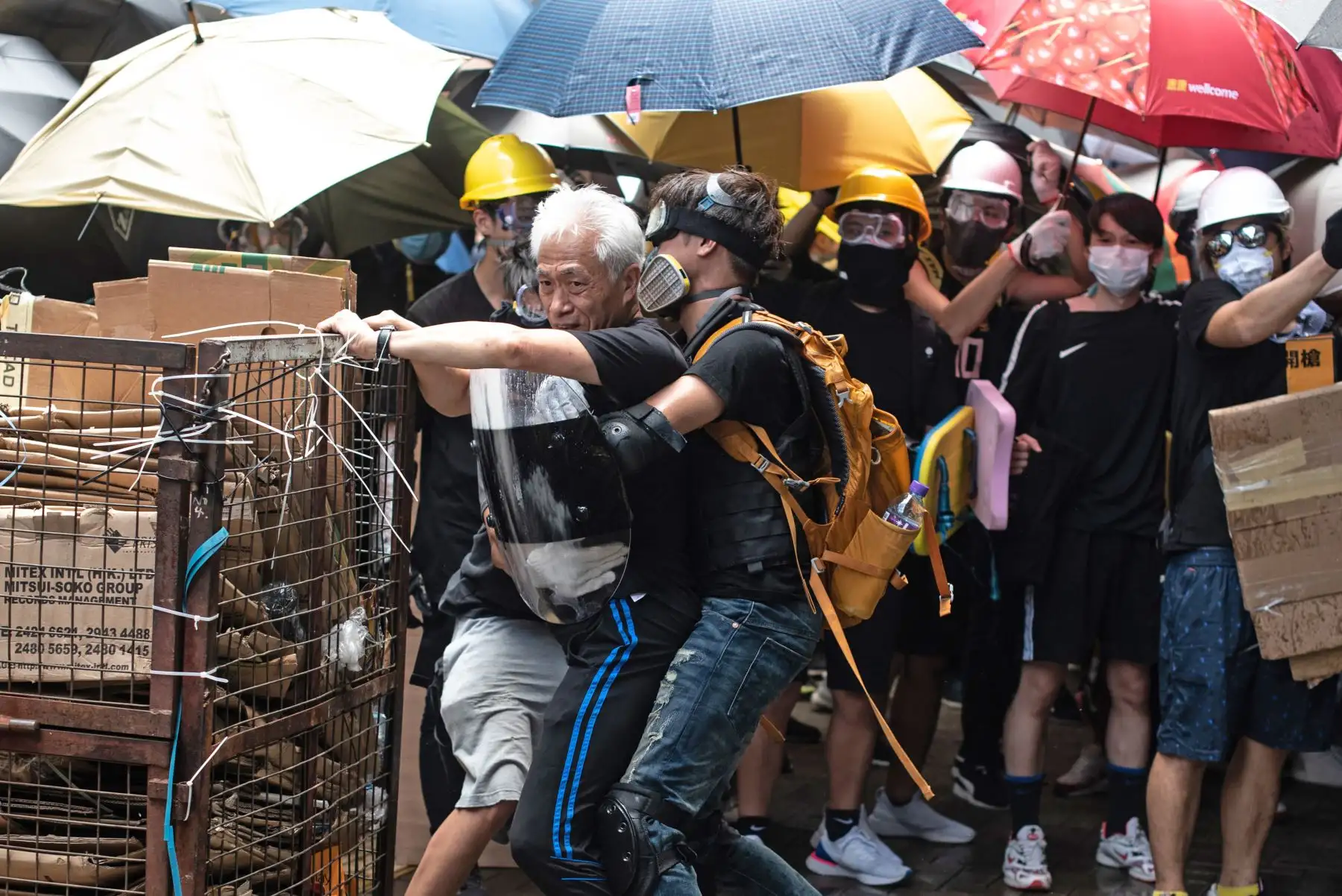 El legislador a favor de la democracia Leung Yiu-chung es retenido por los manifestantes mientras intenta evitar que intenten romper una ventana en la sede del gobierno en Hong Kong el 1 de julio de 2019 en el 22 aniversario de la entrega de la ciudad de Gran Bretaña a China. Foto: AFP