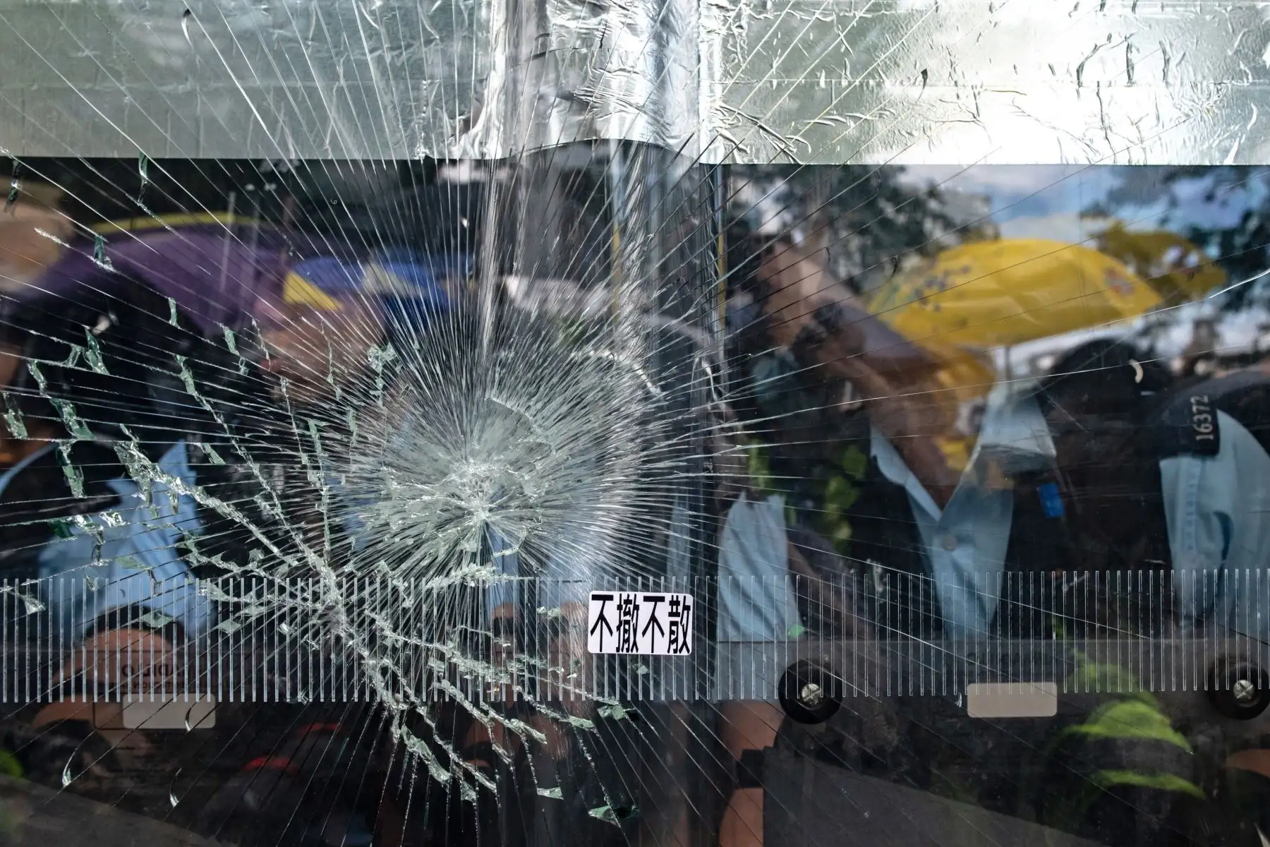 Un cartel que dice "No retroceda hasta que se retire por completo" aparece en una ventana rota cuando los manifestantes intentan romperla en la sede del gobierno en Hong Kong el 1 de julio de 2019 en el 22 aniversario de la entrega de la ciudad de Gran Bretaña a China. Foto: AFP