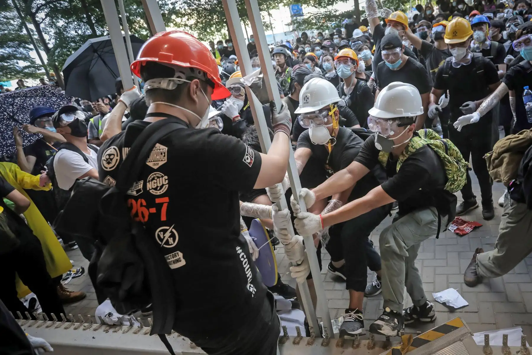 Manifestantes rompen una cerca cuando intentan irrumpir en la sede del gobierno en Hong Kong. Foto: AFP