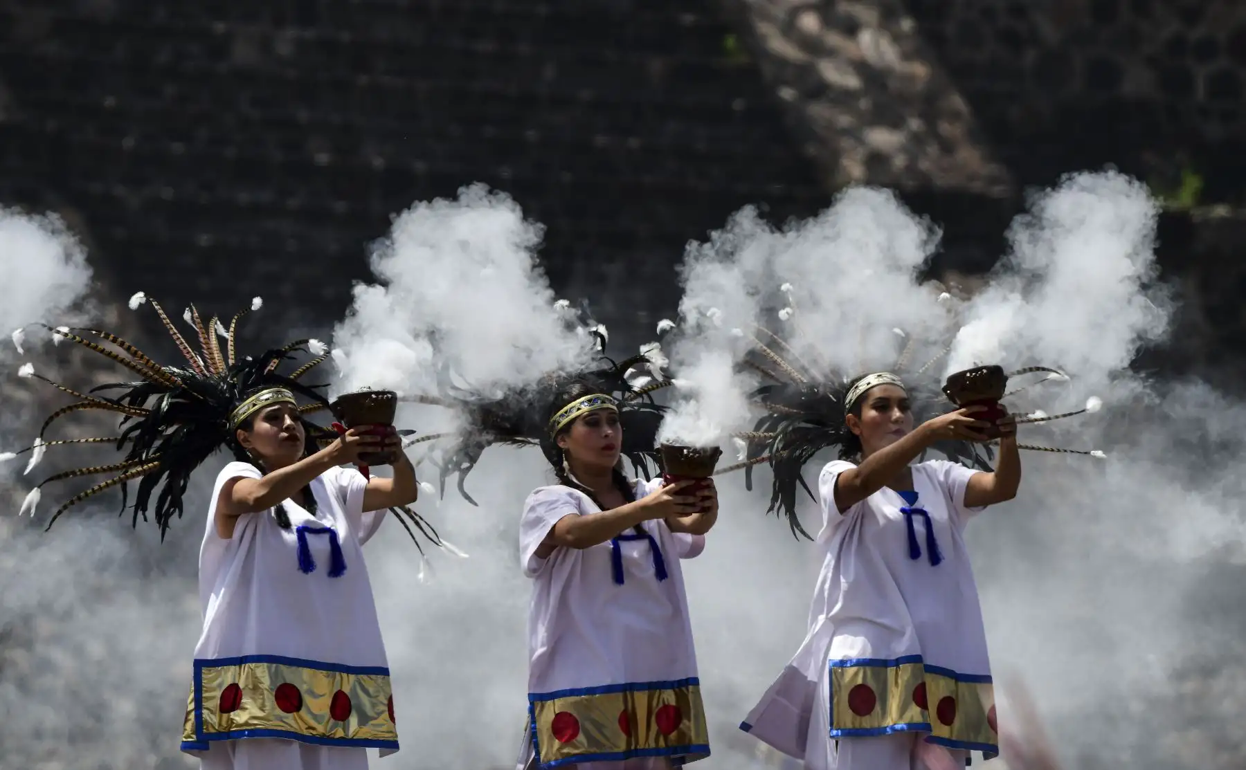 Los artistas recrean una danza azteca en el sitio arqueológico de Teotihuacán, en México, durante la ceremonia de encendido de la antorcha que se llevará a los Juegos Panamericanos de Lima. Foto: AFP.