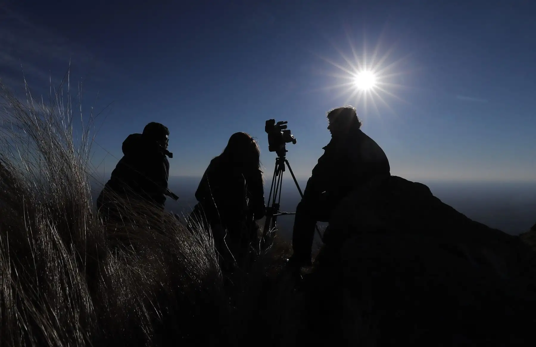 Espectadores al filo de la montaña, observan el sol durante el eclipse solar total, este martes en la ciudad de Merlo, San Luis (Argentina).
Foto: EFE