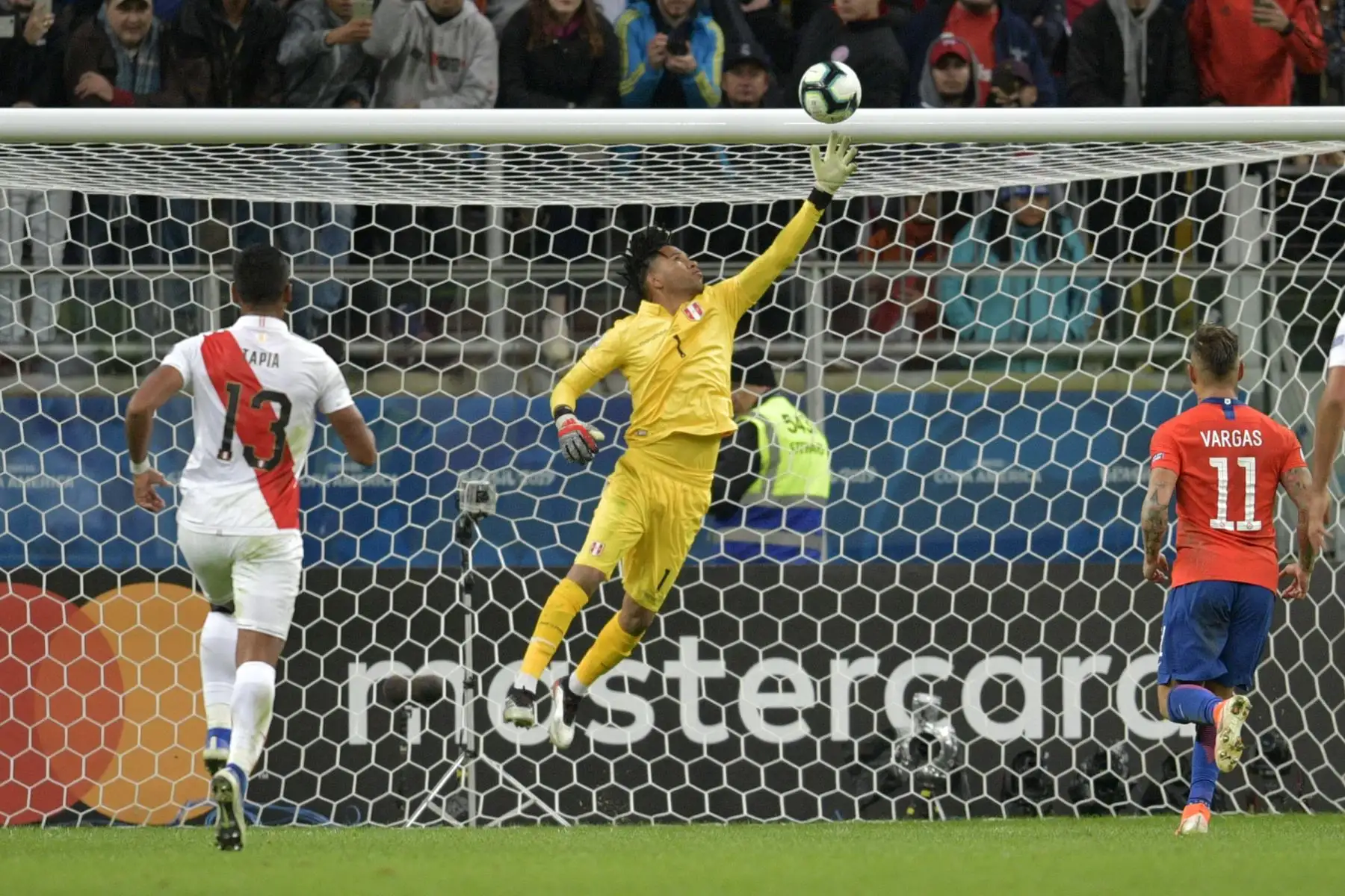 El portero de Perú, Pedro Gallese, detiene un penal por parte del chileno Eduardo Vargas (R) durante su semifinal del torneo de fútbol de la Copa América.
Foto: AFP