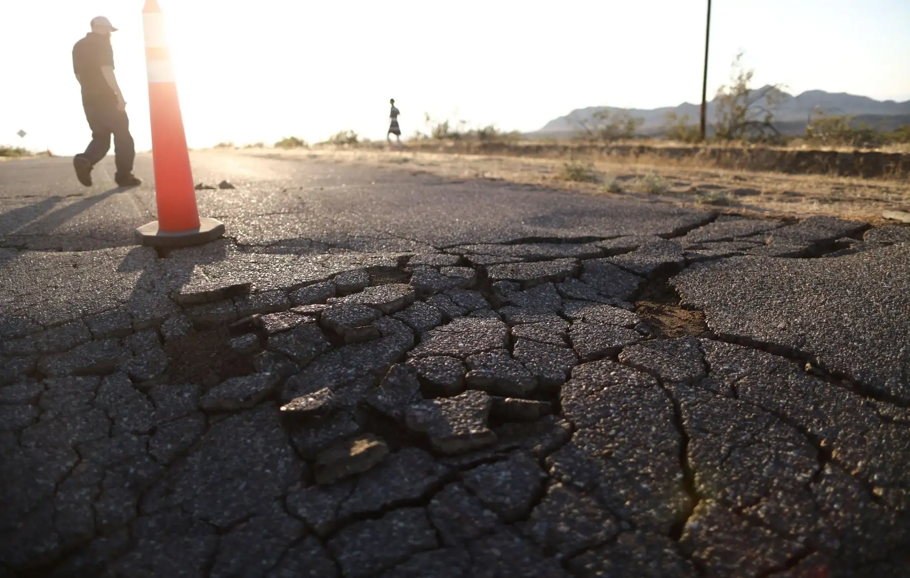 La gente camina cerca de las grietas en el camino después de que un terremoto de magnitud 6.4 golpeara el área, cerca de Ridgecrest, California. El terremoto fue el más grande en golpear el sur de California en 20 años.Foto.AFP