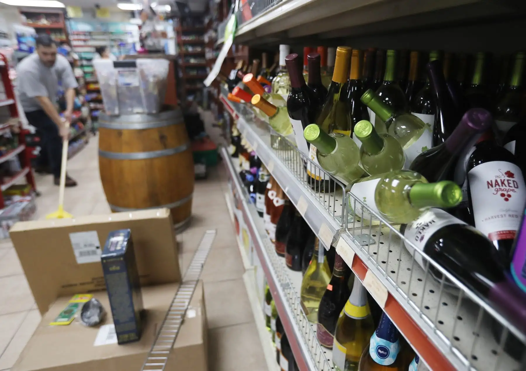 Un trabajador se limpia en una tienda de licores después de un terremoto de magnitud 6.4 que azotó el área y derribó botellas en la tienda el 4 de julio de 2019 cerca de Ridgecrest, California.Foto:AFP