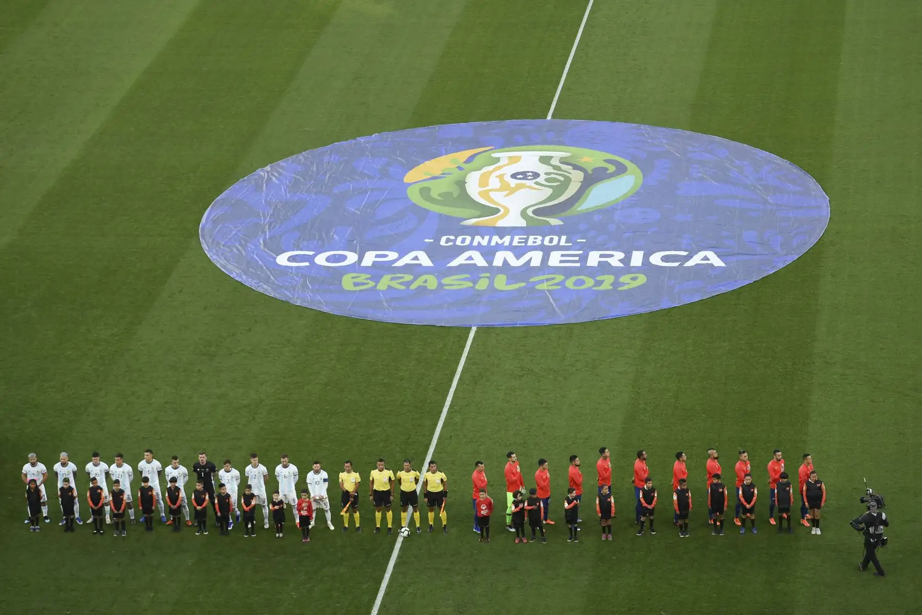 Los jugadores de Argentina (L) y Chile escuchan sus himnos nacionales antes del partido por el tercer lugar en el torneo de fútbol de la Copa América.
Foto: AFP