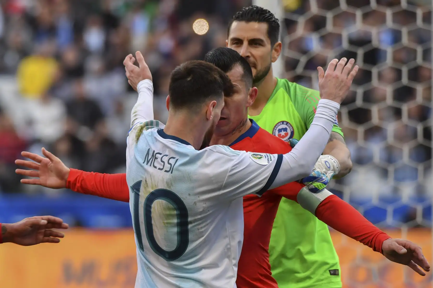 Gary Medel (C) de Chile presiona a Lionel Messi, de Argentina, para que ambos obtengan una tarjeta roja durante su tercer partido en el torneo de fútbol de la Copa América en el Corinthians Arena de Sao Paulo, Brasil.Foto:AFP