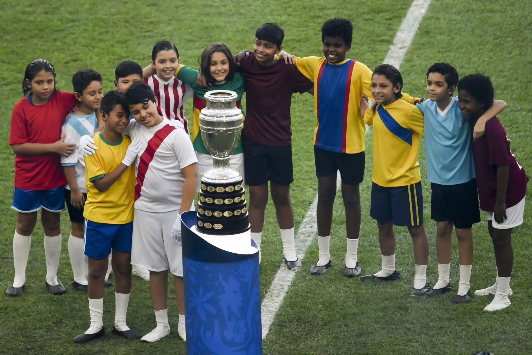 Los niños posan junto al trofeo de la Copa América durante la ceremonia de clausura del torneo de fútbol antes del partido final entre Brasil y Perú en el estadio Maracana en Río de Janeiro, Brasil.Foto.AFP