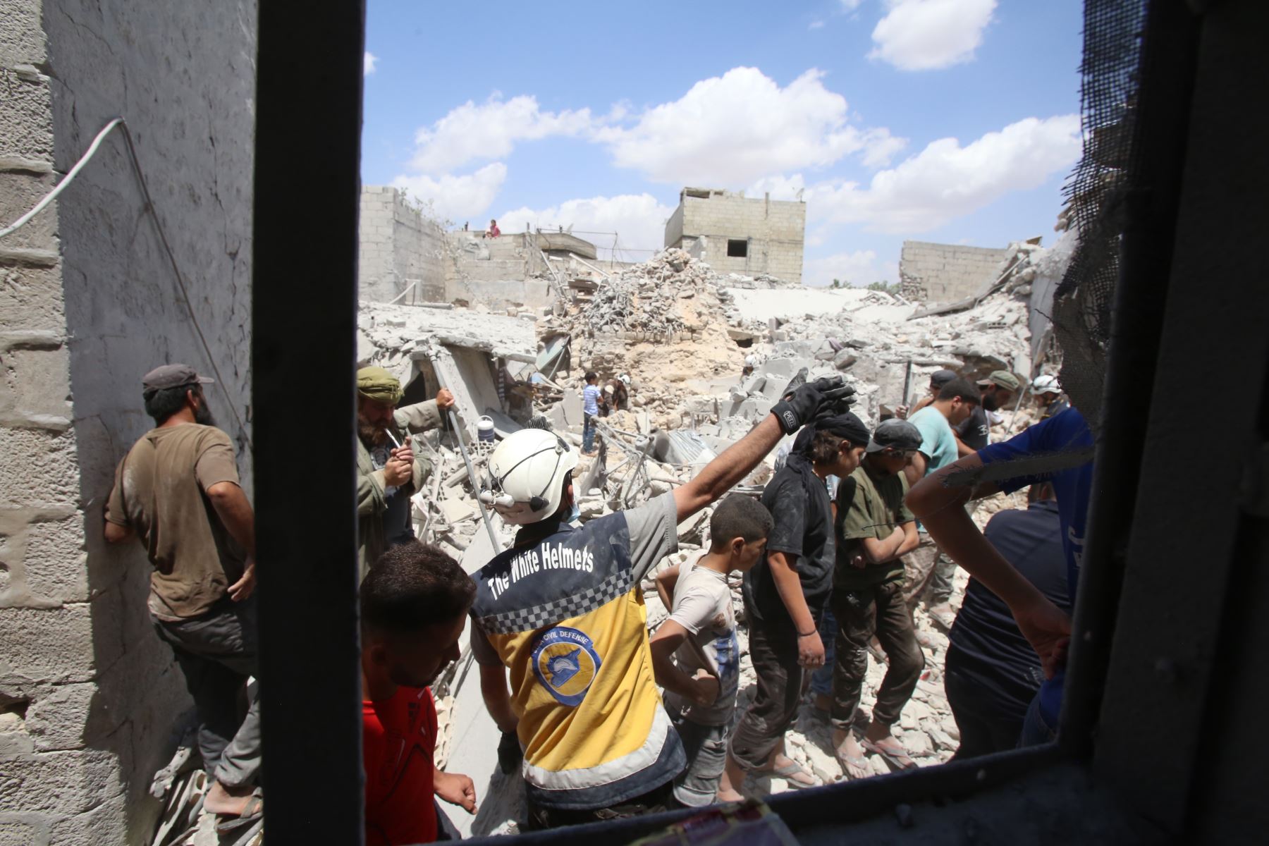 Miembros de la Defensa Civil Siria encuentran víctimas tras un ataque aéreo en la ciudad de Ariha, en el  Siria. Foto: AFP