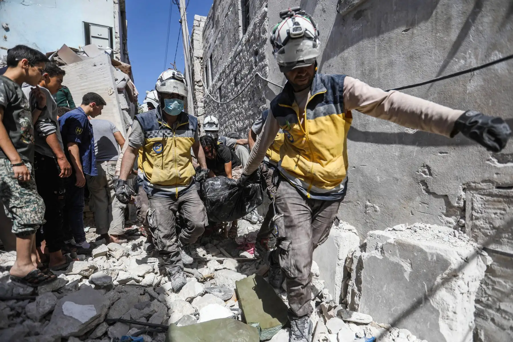 Miembros de la Defensa Civil Siria encuentran víctimas tras un ataque aéreo en la ciudad de Ariha, en el  Siria. Foto: AFP