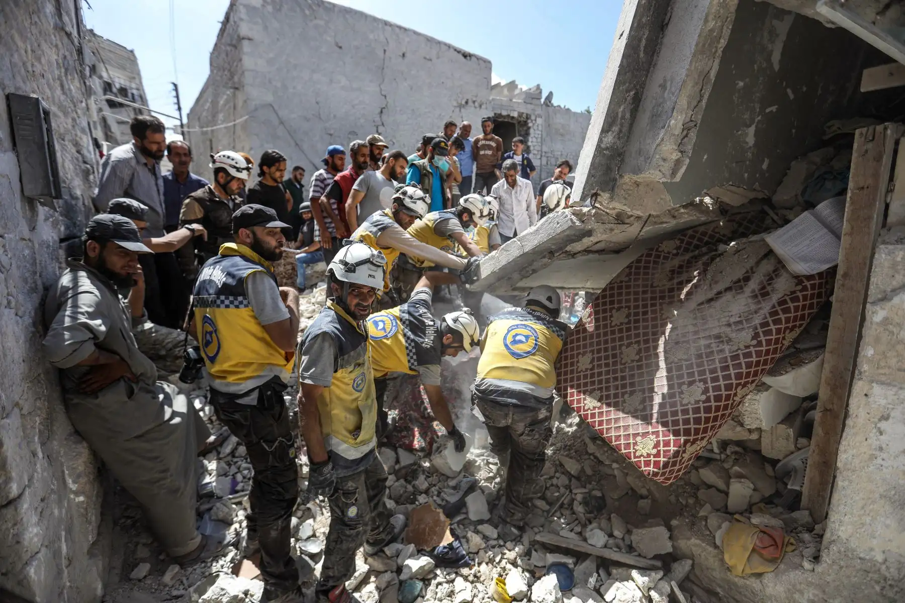 Miembros de la Defensa Civil Siria encuentran víctimas tras un ataque aéreo en la ciudad de Ariha, en el  Siria. Foto: AFP