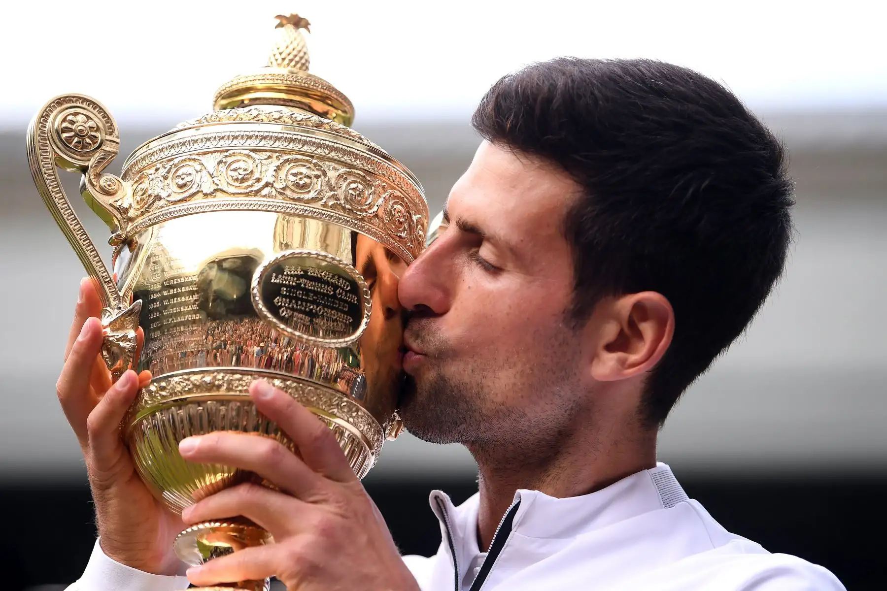 Novak Djokovic de Serbia besa el trofeo del ganador después de vencer a Roger Federer de Suiza durante la final de individuales masculinos el día trece del Campeonato de Wimbledon 2019.
Foto: AFP