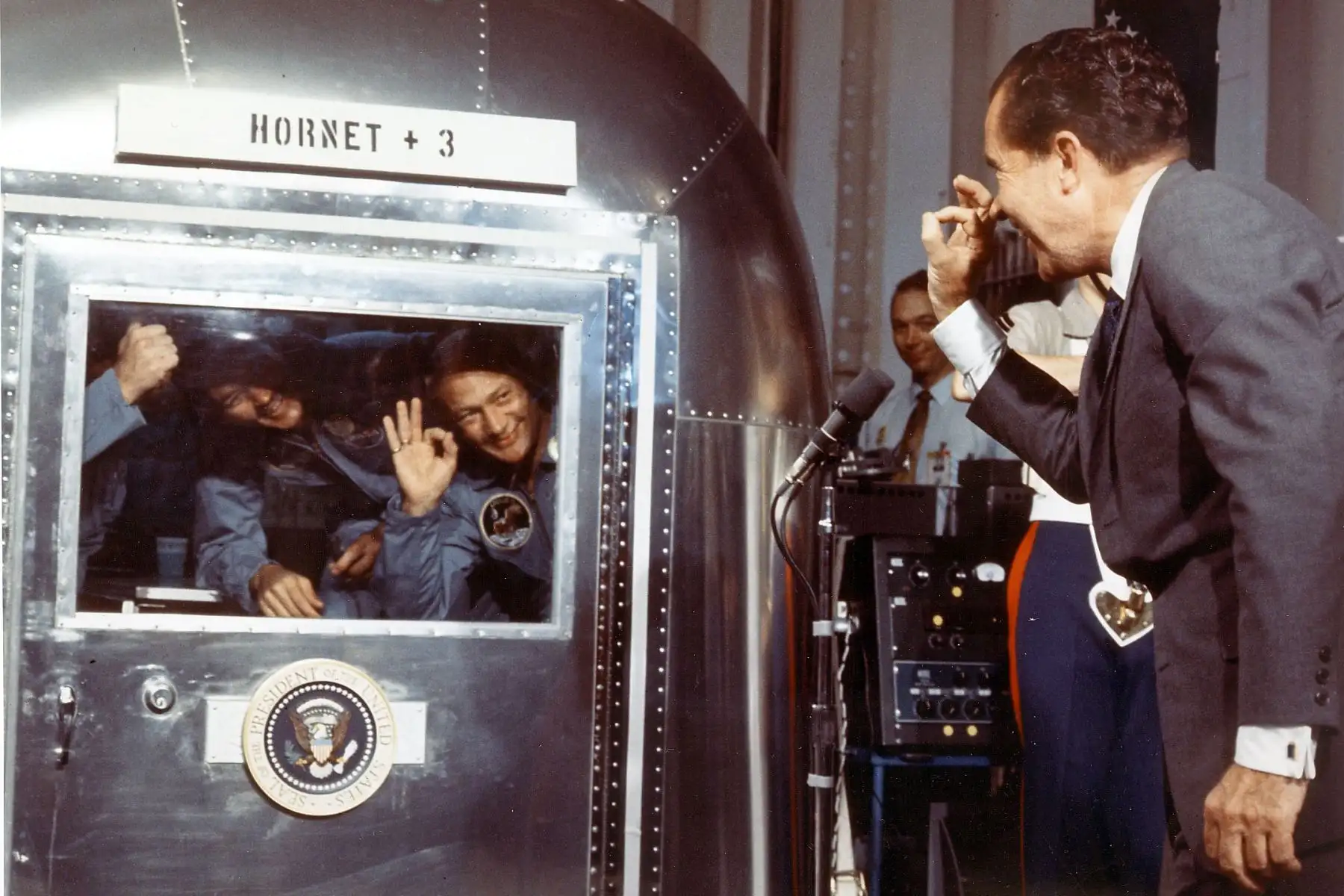 El presidente Richard M. Nixon y los astronautas del Apolo 11 intercambian saludos a través de la ventana de la Instalación de cuarentena móvil. Foto: AFP