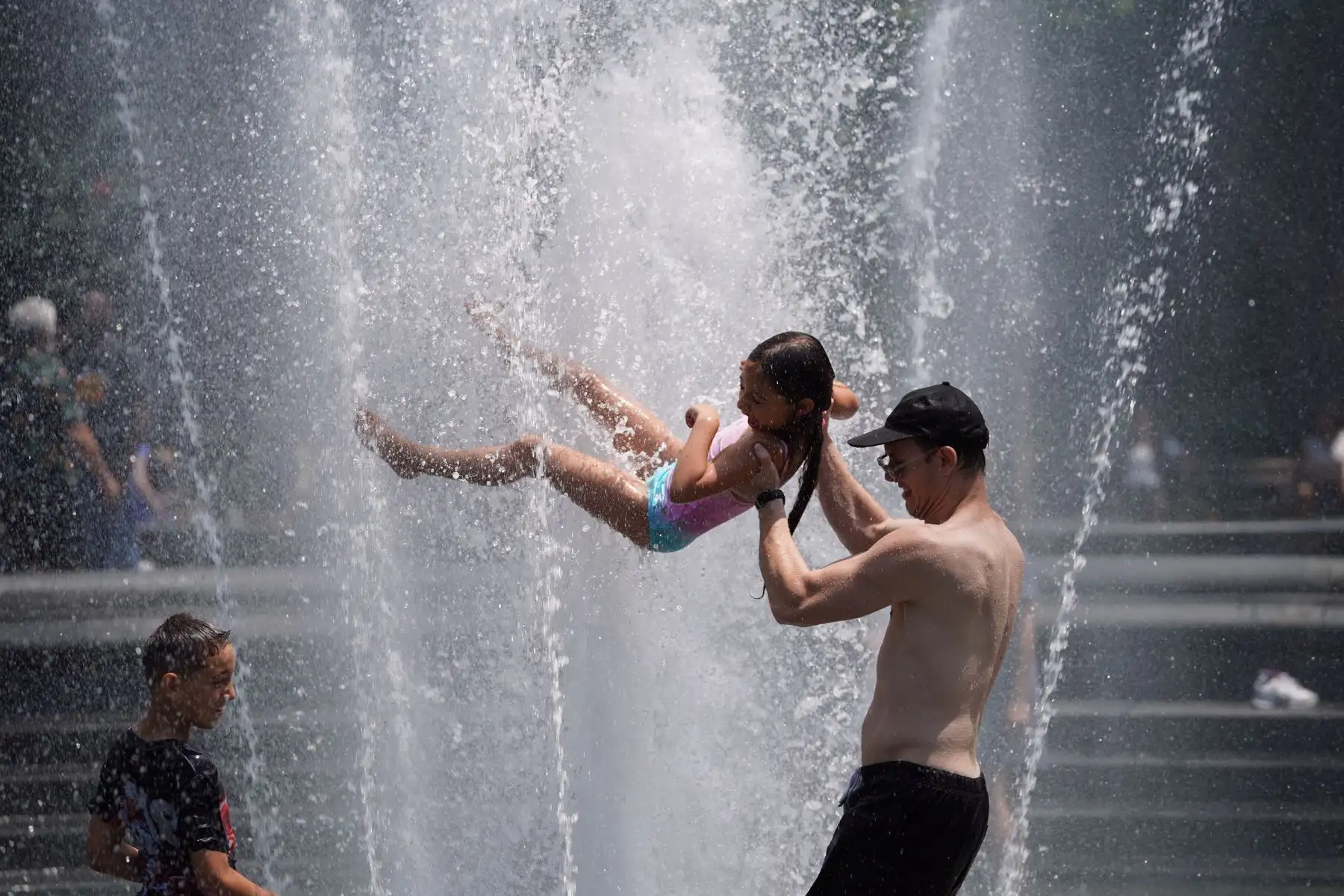 La gente se enfría en una fuente en Washington Square Park en Nueva York.  Según el Servicio Nacional de Meteorología,  una ola de calor golpea el medio oeste y el este de los EE. UU. AFP