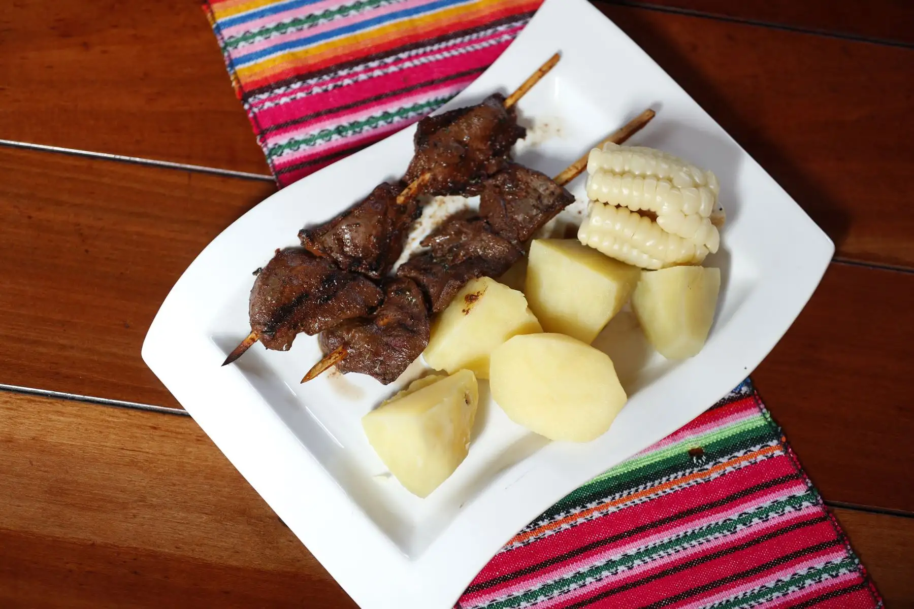 Sabor del más puro corazón de res. El choclo y las papas blancas son el acompañamiento perfecto para este piqueo peruano, que en realidad tiene contundencia de fondo. Foto: ANDINA/Josue Ramos