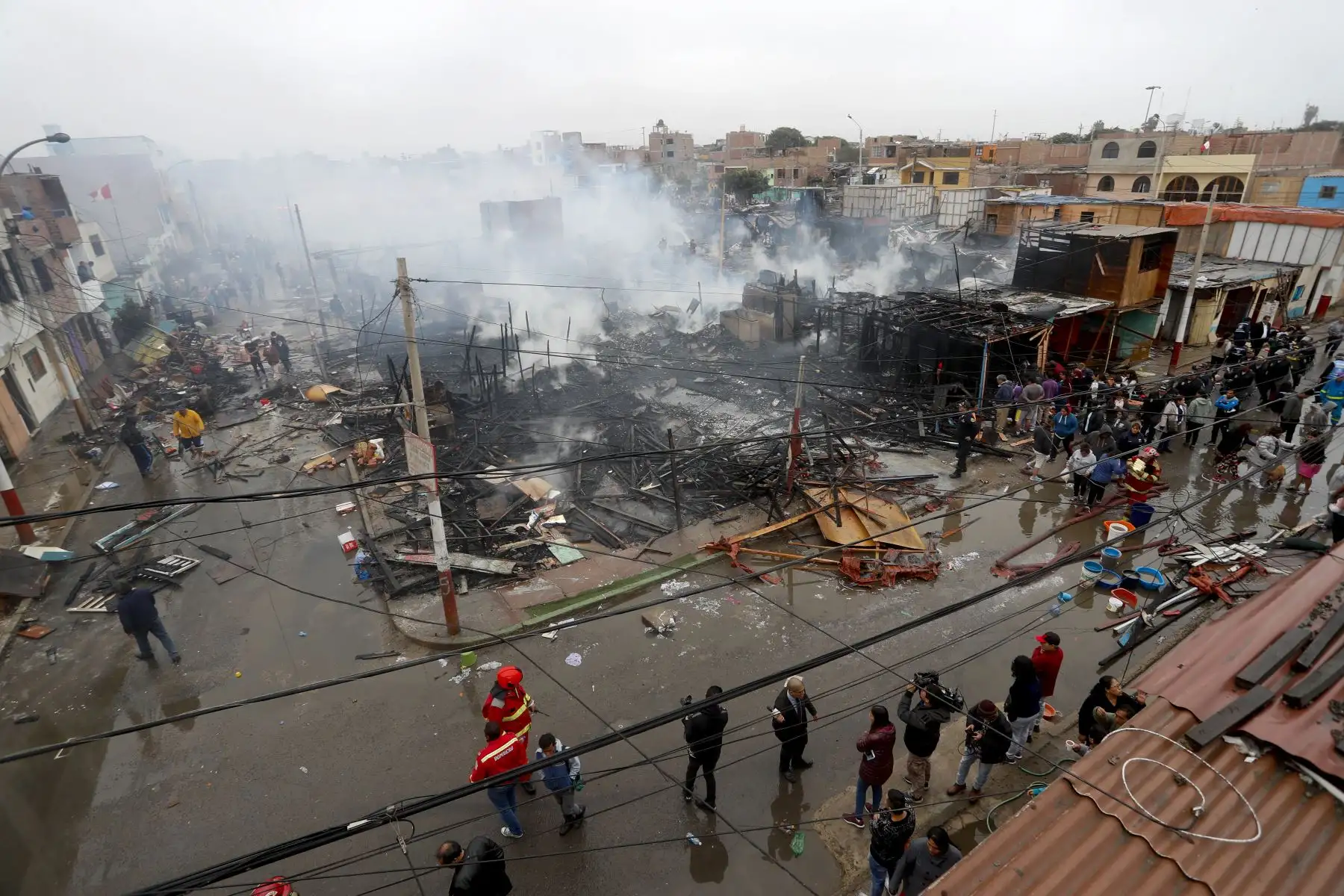 Bomberos trabajan intensamente para apagar el incendio que consume más de 200 viviendas en el Callao. Foto: ANDINA/Josue Ramos