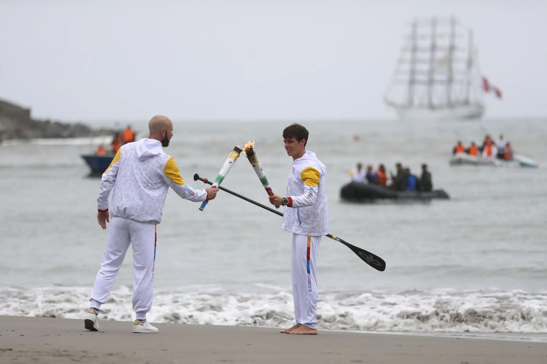 Recibió la antorcha a tierra el deportista Itzel Delgado de la disciplina de stand UP paddle
Le entrega la antorcha en tierra a Luis Horna ex tenista. Foto: ANDINA/Josue Ramos