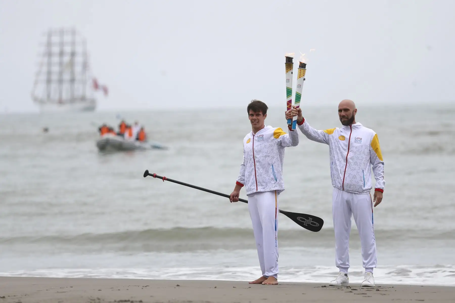 Recibió la antorcha a tierra el deportista Itzel Delgado de la disciplina de stand UP paddle
Le entrega la antorcha en tierra a Luis Horna ex tenista. Foto: ANDINA/Josue Ramos