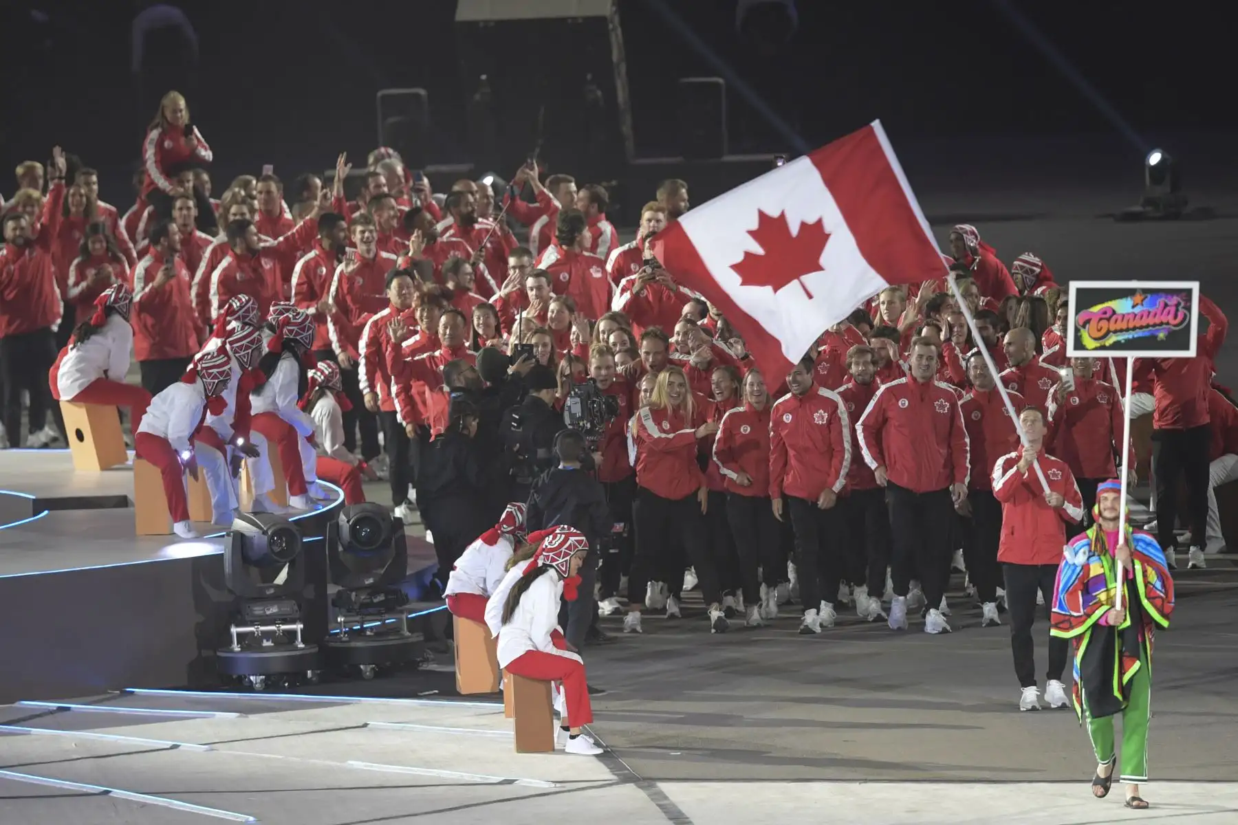 El portador de la bandera de Canadá, el jugador de hockey sobre césped Scott Tupper, encabeza su delegación durante el Desfile de las Naciones de la ceremonia de apertura de Lima 2019.Foto.AFP