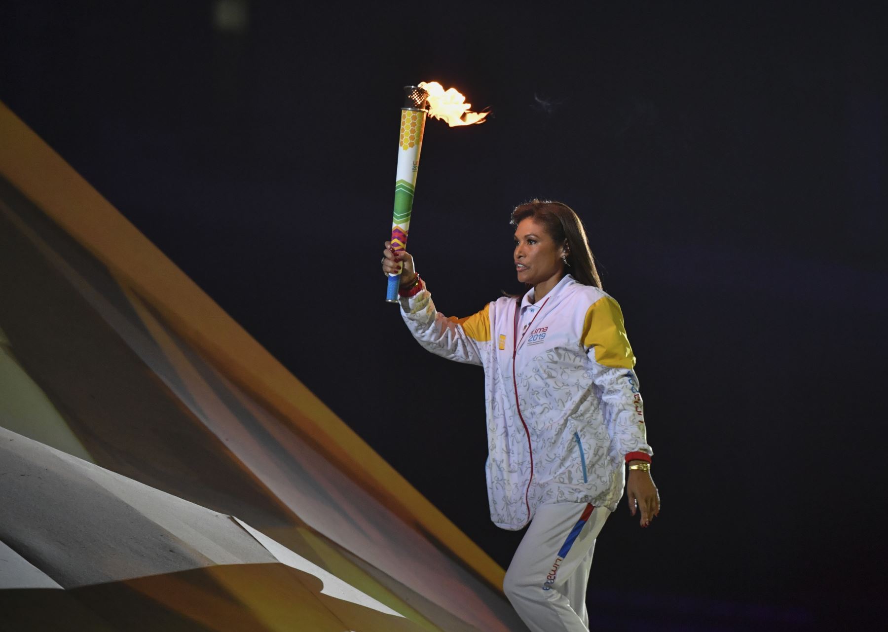 La ex jugadora de voleibol peruana Cecilia Tait lleva la antorcha para encender la llama durante la ceremonia de apertura de los Juegos Panamericanos de Lima 2019.
Foto: AFP