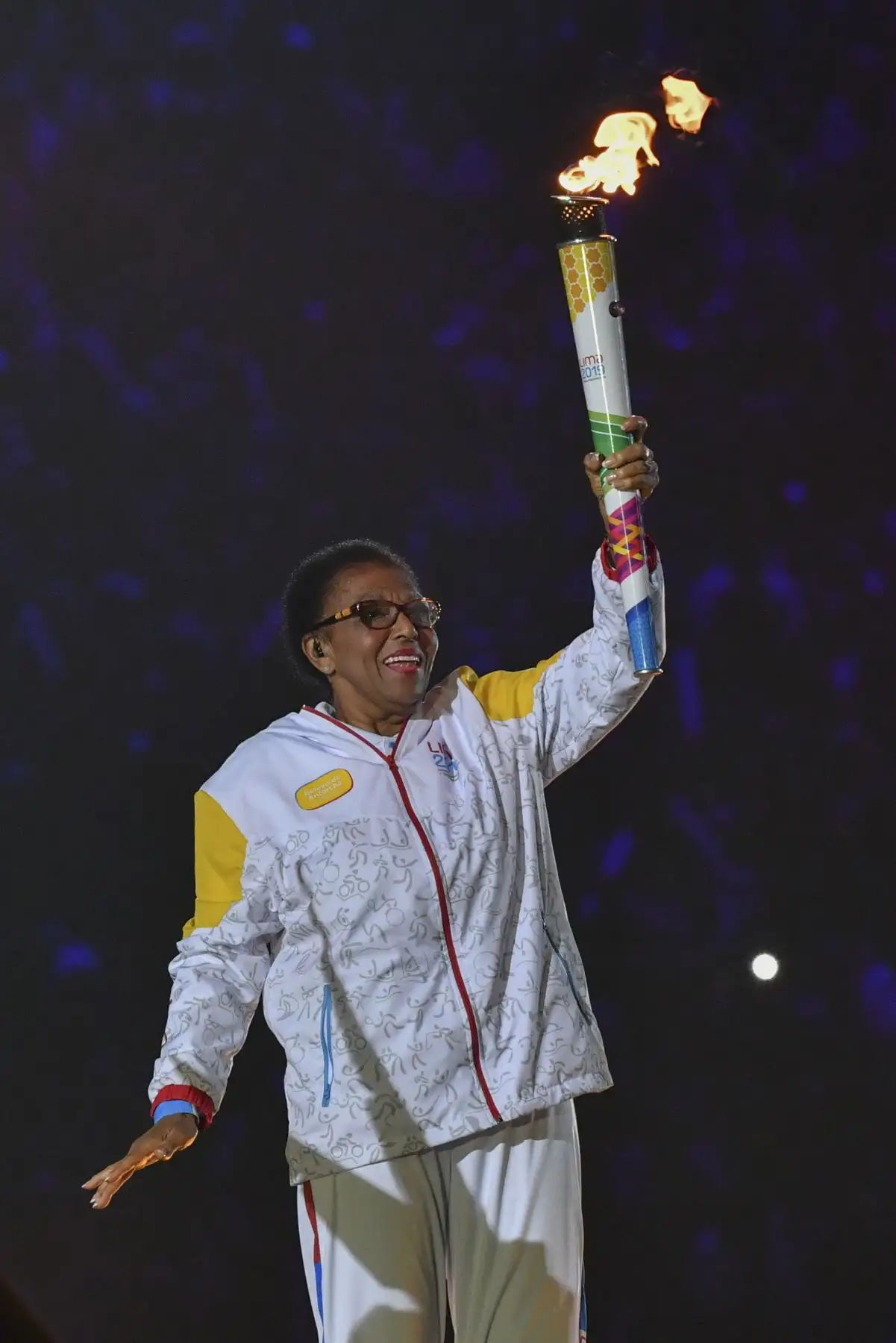 La exjugadora de voleibol peruana Lucha Fuentes lleva la antorcha durante la ceremonia de inauguración de los Juegos Panamericanos Lima 2019. Foto: Lima 2019.