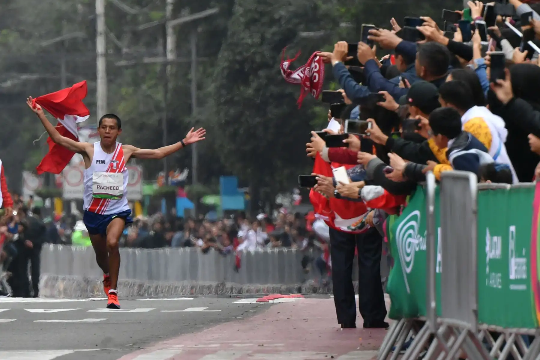 Christian Pacheco, de Perú, saluda a la gente cuando se acerca a la línea de meta para ganar la medalla de oro en la Maratón masculina de los Juegos Panamericanos Lima 2019 en Lima, Perú, el 27 de julio de 2019. Los Juegos Panamericanos duran hasta el 11 de agosto. AFP