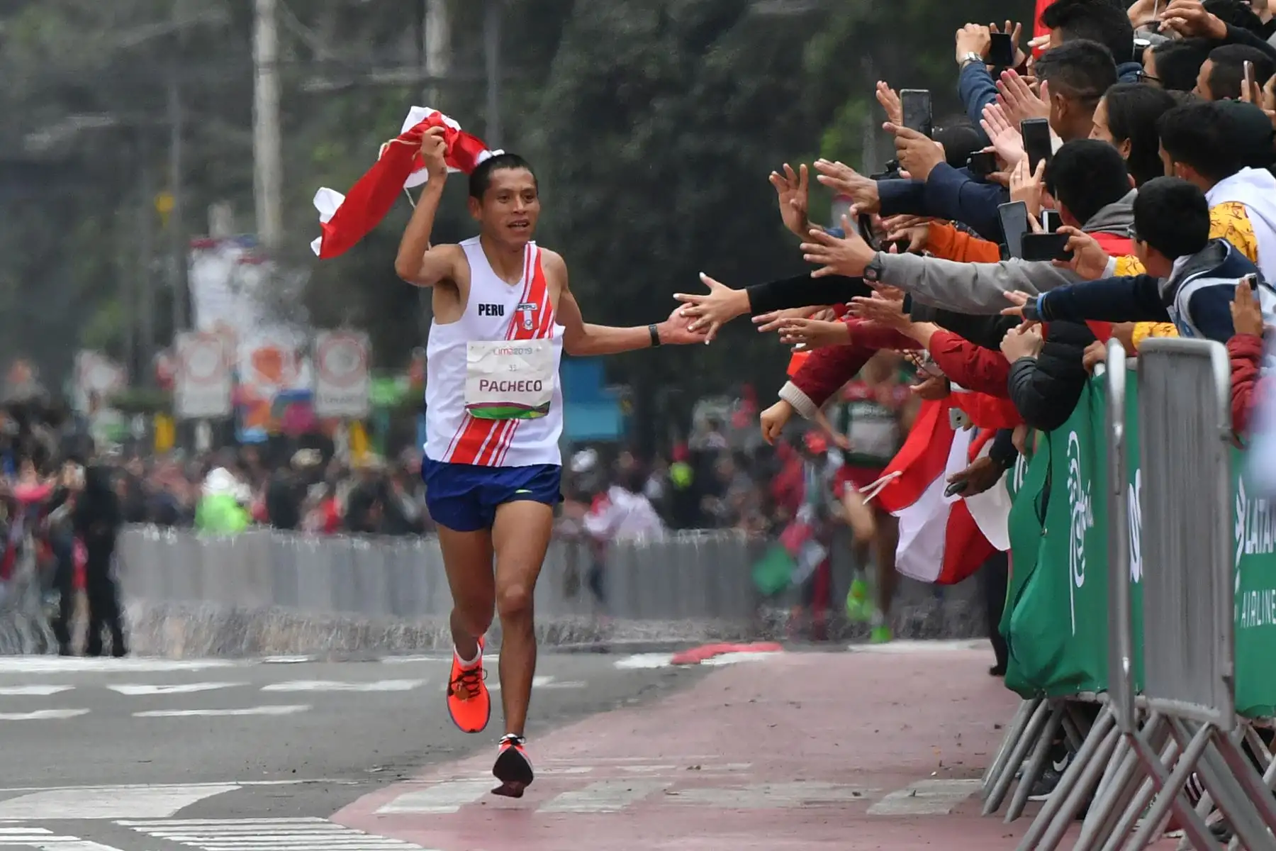 Christian Pacheco, de Perú, saluda a la gente cuando se acerca a la línea de meta para ganar la medalla de oro en la Maratón masculina de los Juegos Panamericanos Lima 2019 en Lima, Perú, el 27 de julio de 2019. Los Juegos Panamericanos duran hasta el 11 de agosto. AFP