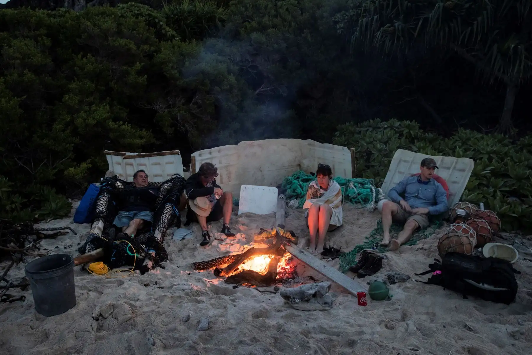 Esta imagen muestra a los miembros del equipo de limpieza de playas sentados alrededor de un fuego después de recoger basura de una playa en la isla Henderson, un miembro deshabitado de las Islas Pitcairn. archipiélago en el Océano Pacífico Sur. AFP