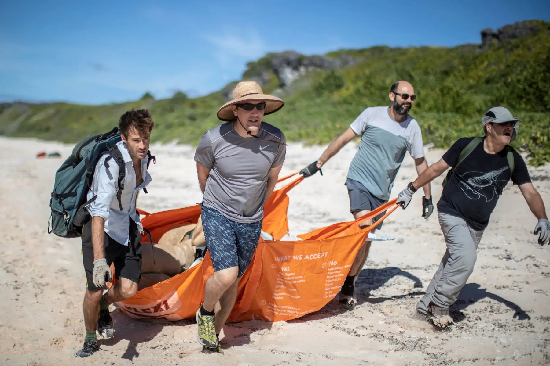 El grupo de medios Stuff con sede en Nueva Zelanda muestra a los miembros del equipo de limpieza de playas Johnny Briggs (L), Brett Howell (2 ° L), James Beard (2 ° R) y Robin Shackell (R) recogiendo basura de una playa en la Isla Henderson, un miembro deshabitado del archipiélago de las Islas Pitcairn en el Océano Pacífico Sur. AFP