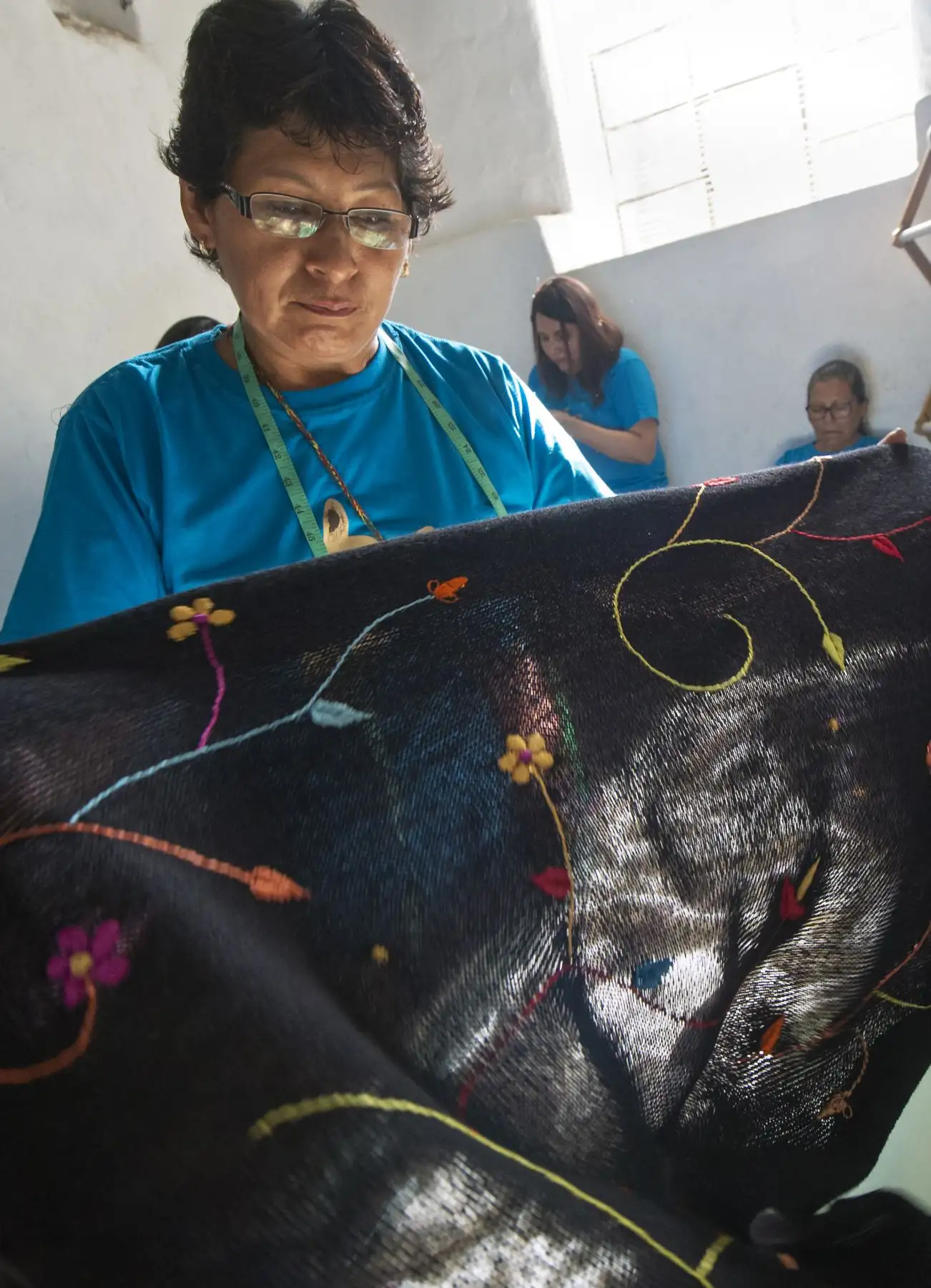 Una mujer revisa las prendas de lana de alpaca en busca de defectos en un taller en Arequipa. AFP