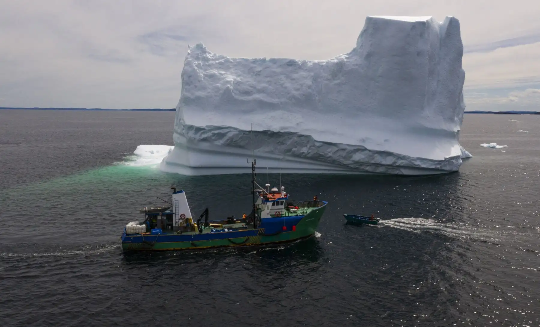 El barco del Capitán Edward Kean pasando un Iceberg en la Bahía de Bonavista, Terranova, Canadá.  El agua Iceberg es considerada pura, ahora se comercializa para un sector único de productos de alta gama. AFP