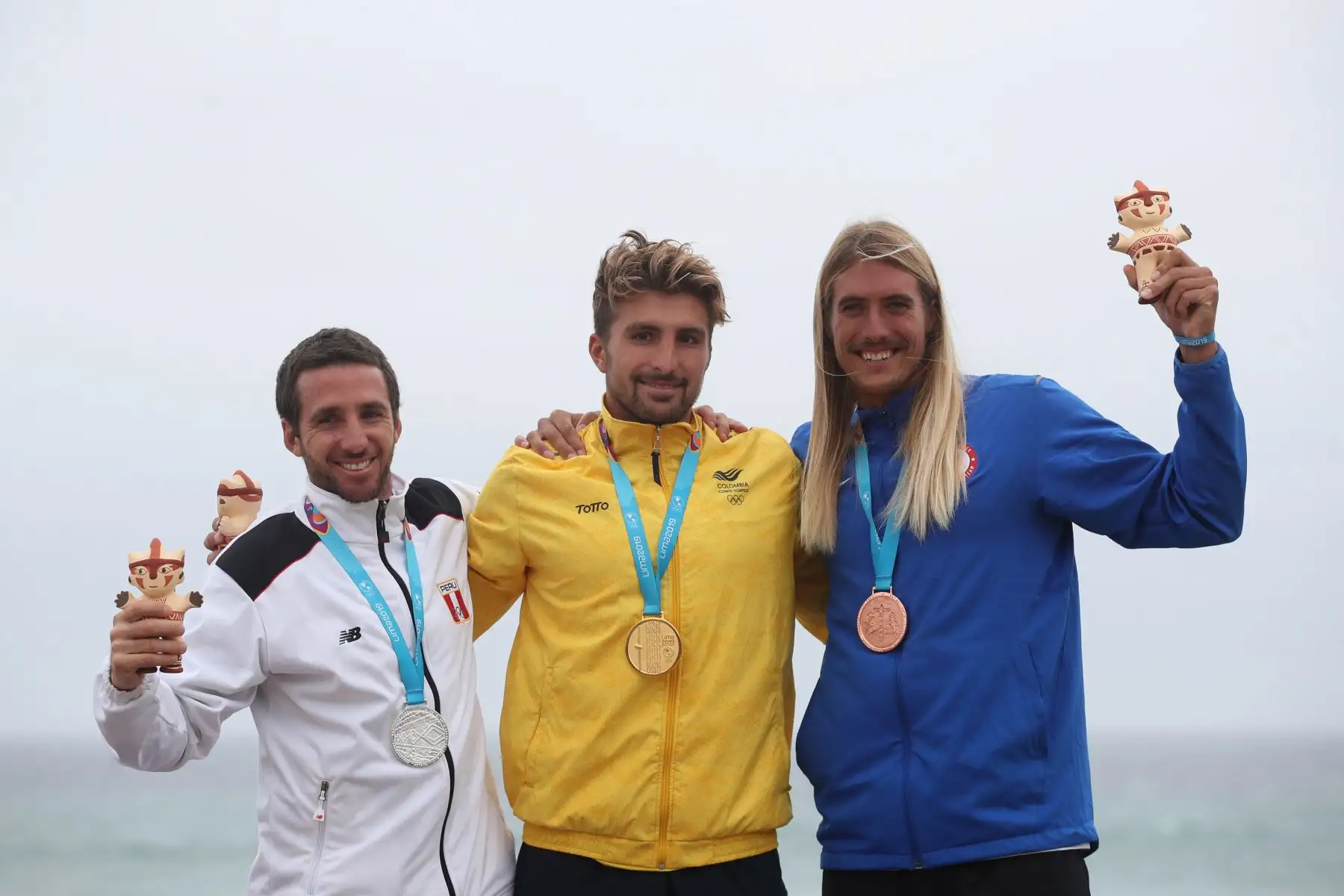 Giorgio Gómez (c) de Colombia, medalla de oro, posa junto a Tamil Martino (i) de Perú, plata, y Daniel Hughes de Estados Unidos, bronce en la premiación de surf SUP masculino en los Juegos Panamericano. 
Foto: EFE