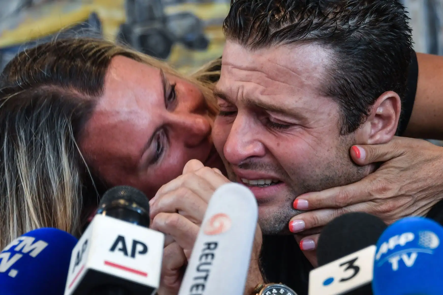 Franky Zapata es consolado por su esposa Krystel mientras se limpia las lágrimas durante una conferencia de prensa en Sangatte después de que tuvo éxito hoy en su segundo intento de cruzar el Canal de la Mancha en un aerodeslizador "Flyboard" . AFP