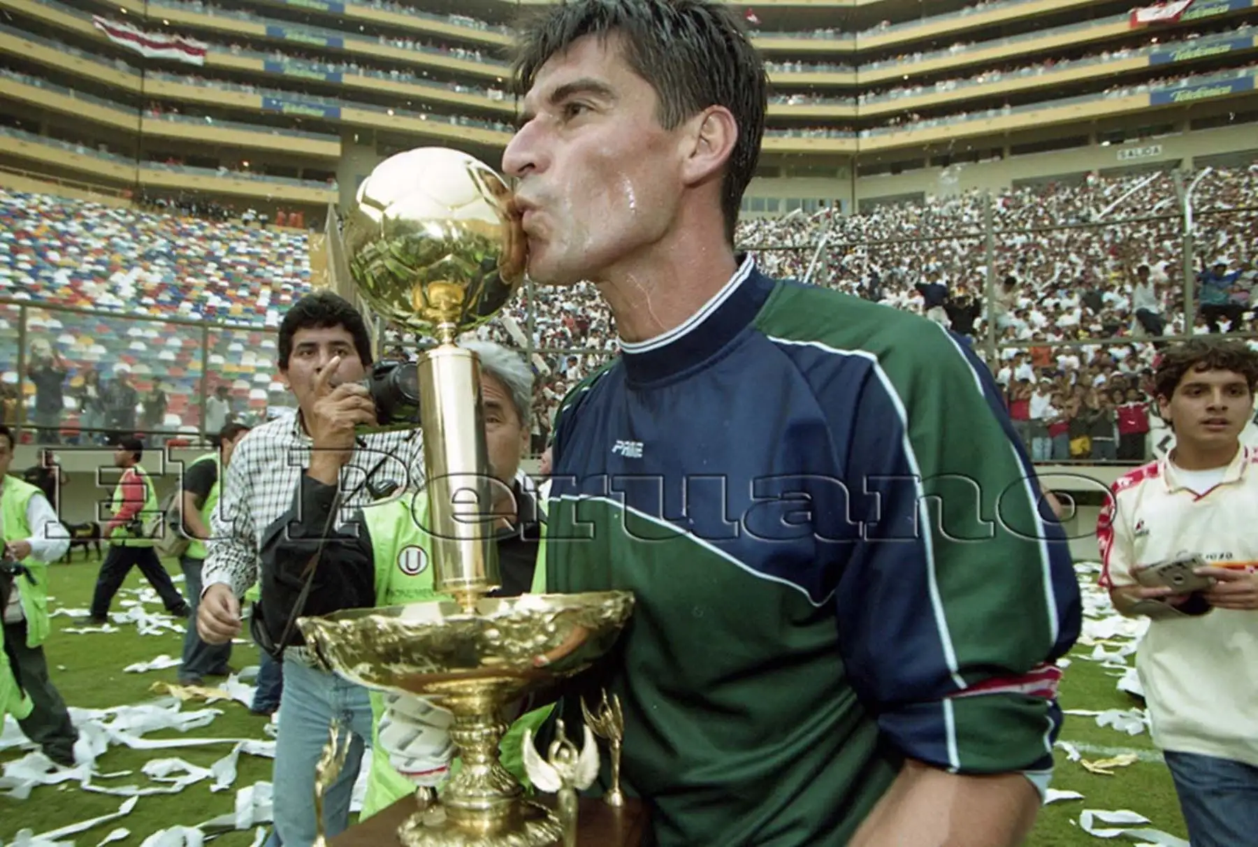 Oscar Ibañez besa la copa que corono campeón a Universitario el año 2000 . Foto: Archivo El Peruano.