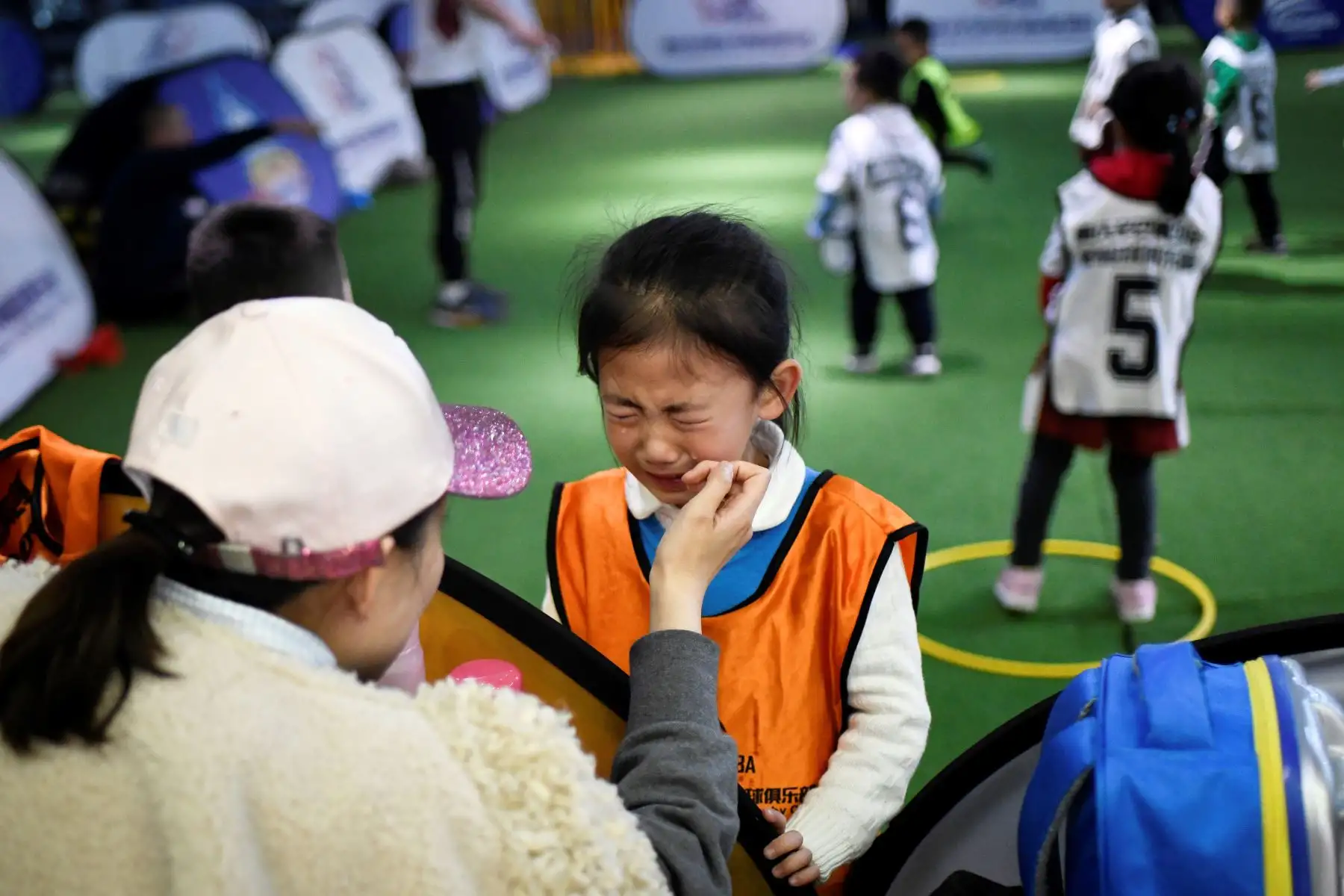 Niña llorando mientras participa en una sesión de entrenamiento en un club de rugby juvenil en el municipio de Chongqing, suroeste de China.
