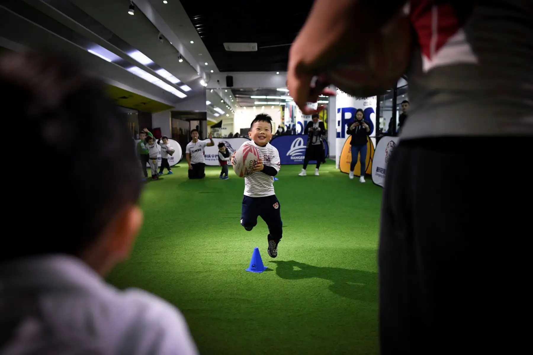 Con entusiasmo los pequeños participan de los entrenamientos en un club de rugby en China. AFP