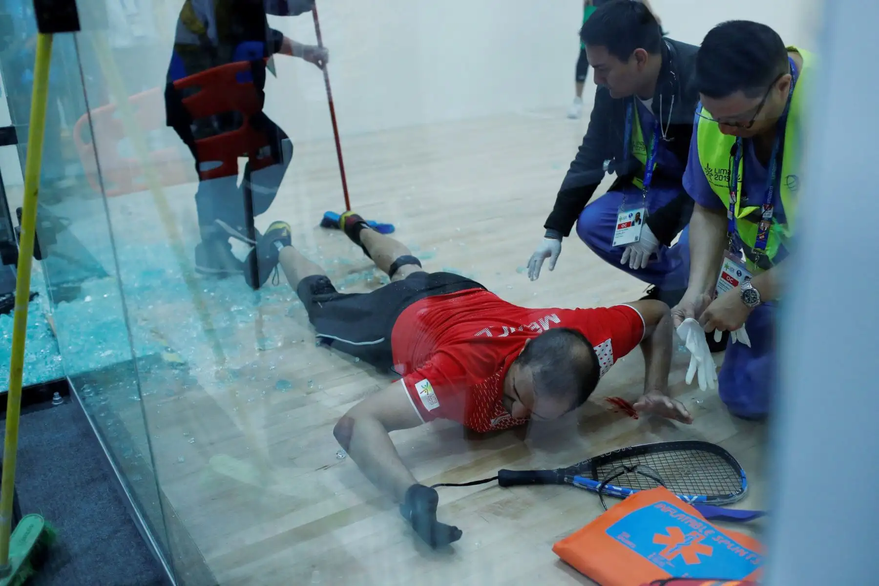 Álvaro Beltrán (abajo) de México espera por atención médica tras romperse la puerta del escenario de la final de raquetbol ante Rodrigo Montoya de México en los Juegos Panamericanos Lima 2019.
Foto: EFE