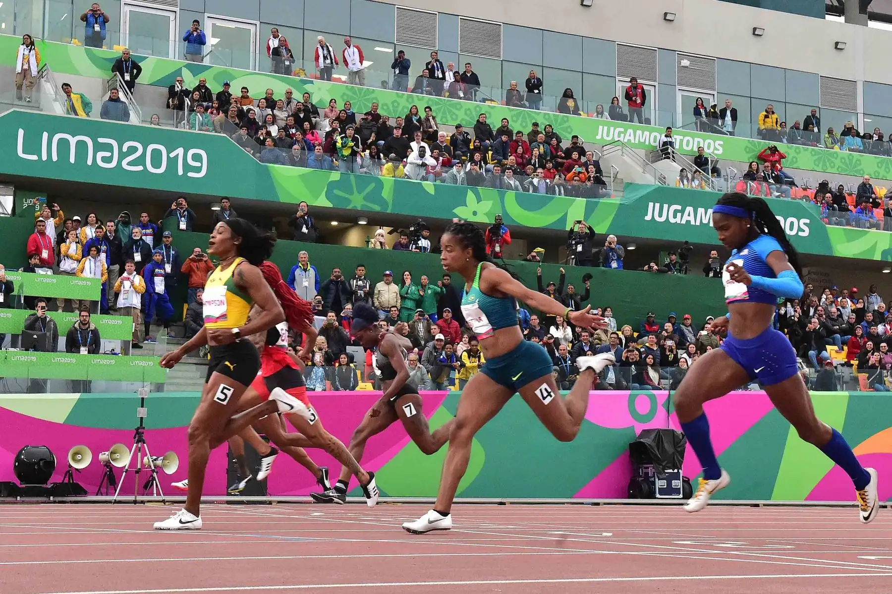 Los atletas cruzan la línea de meta de la final de atletismo femenino de 100 metros durante los Juegos Panamericanos de Lima 2019.
Foto: AFP