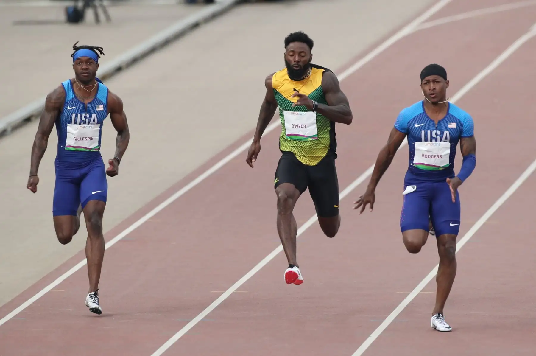 Cravon Gillespie (i) de Estados Unidos, Ray Dwyer (c) de Jamaica y Michael Rodgers de Estados Unidos compiten en la final de los 100m masculino en los Juegos Panamericanos Lima 2019.
Foto: EFE