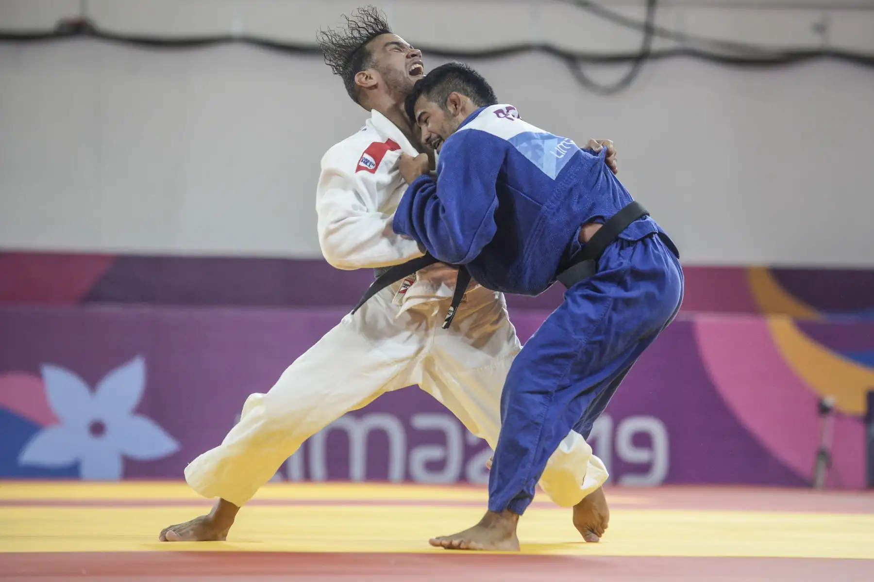 El cubano Magdiel Estrada (L) compite contra el peruano Alonso Wong en su concurso final de medalla de oro de 73 kg de judo masculino durante los Juegos Panamericanos de Lima 2019.Foto.AFP