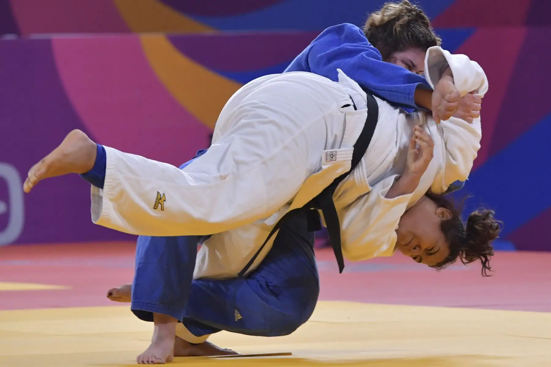 La peruana-venezolana  Juliana Bolívar y la estadounidense Nina Cutro-Kelly (arriba) compiten durante una pelea por la Medalla de Bronce Femenina de +78 kg en los Juegos Panamericanos en Lima 2019. Foto: AFP