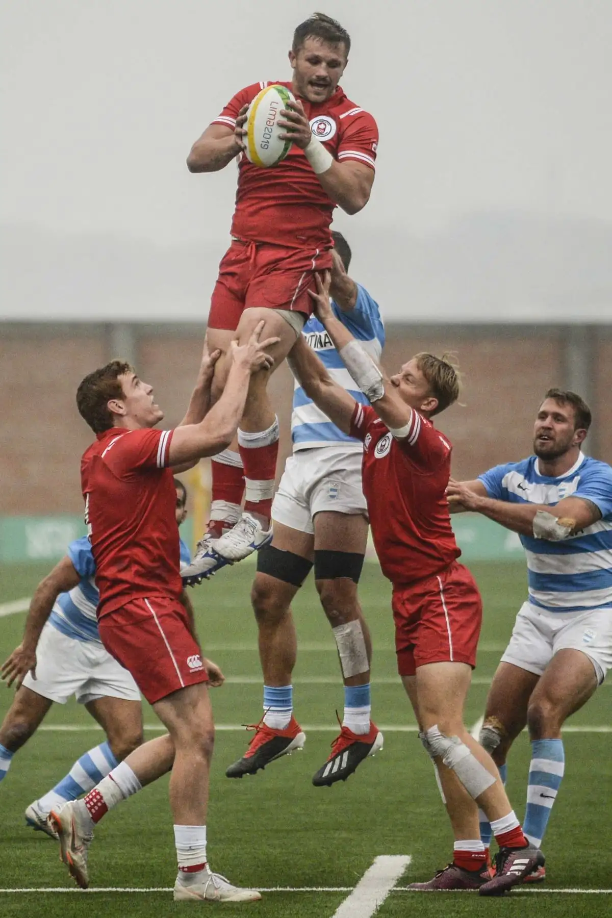 Jugadores de Argentina y Canadá luchan por el balón durante el partido por la medalla de oro de rugby sietes masculino en los Juegos Panamericanos Lima 2019. AFP