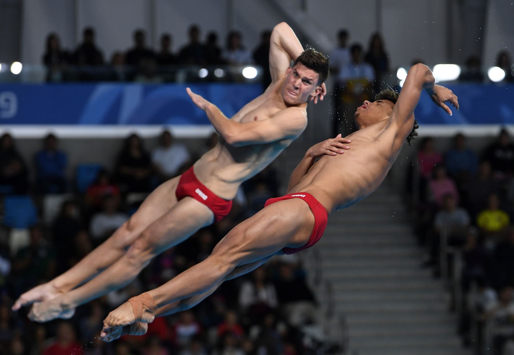 El cubano José ALfredo Quintana (izq.) Y Laydei Domínguez compiten en la final de trampolín sincronizado masculino de 3 m de la competencia de buceo durante los Juegos Panamericanos Lima 2019. AFP